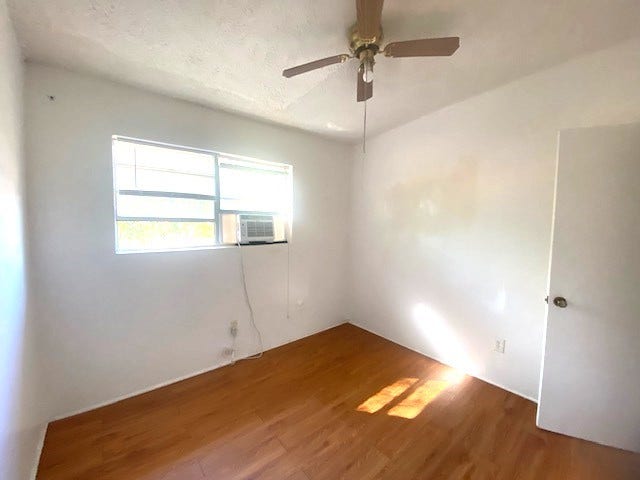 215 Avenue E, South Houston, TX 77587 Secondary bedroom with ceiling fan and ac window unit.