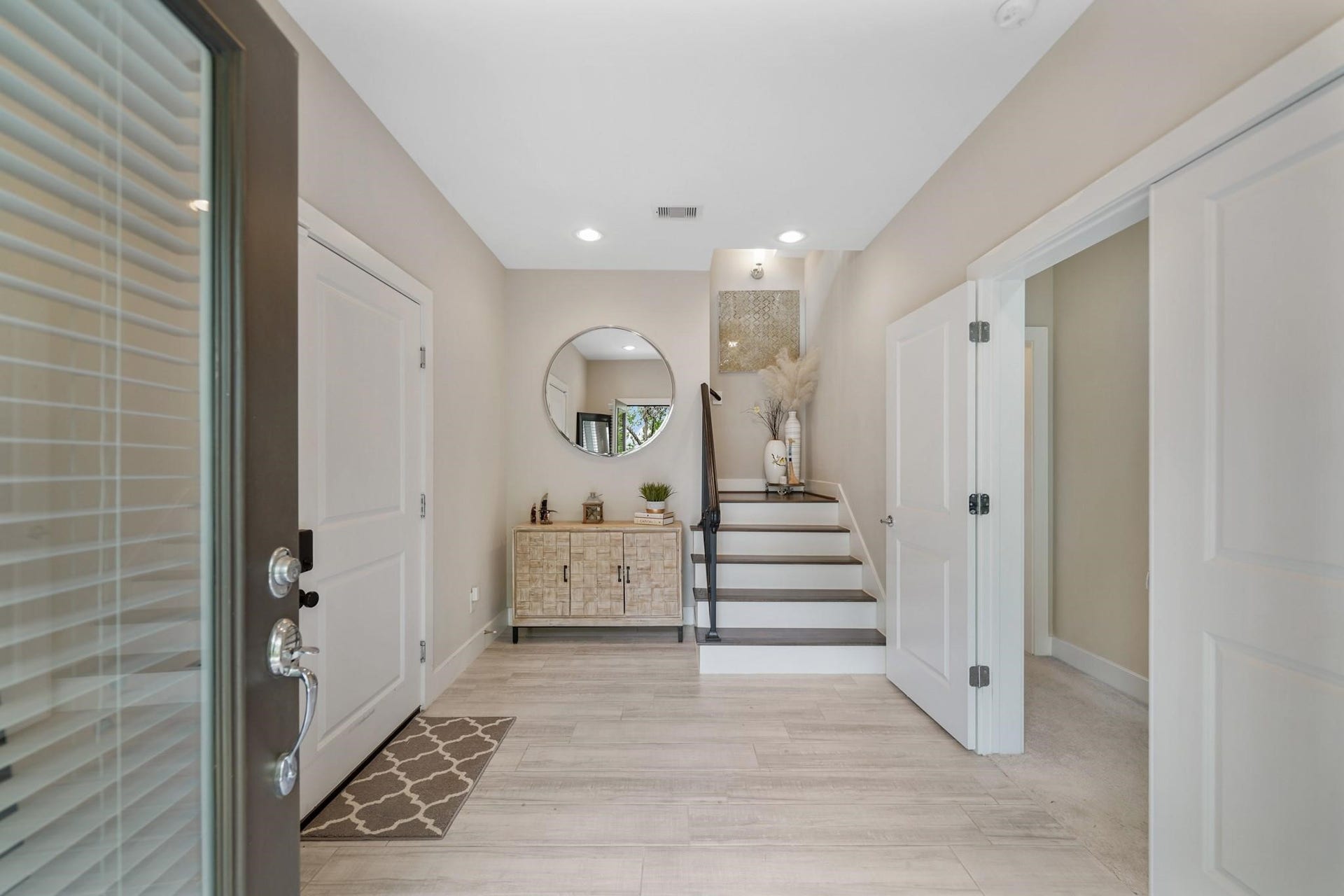 1824 Bonner Street, Houston, TX 77007 The foyer of the home has a high ceiling with recessed lighting, space for accent furniture & tile flooring. Included is a wrought iron staircase with hardwood treads leading to the second level of the home and access to the home's attached garage is provided just through the door on the left and includes an automated smart door lock.