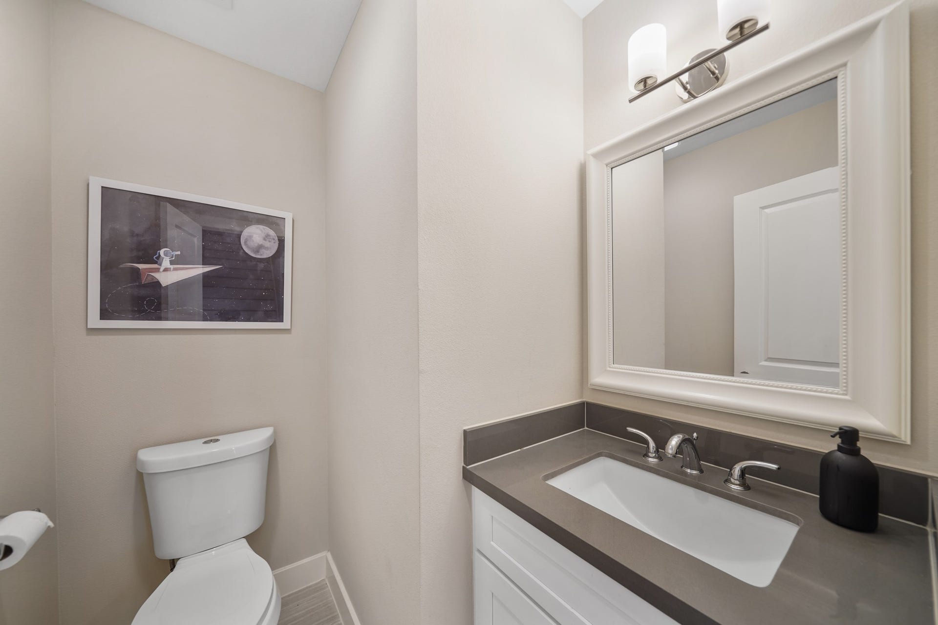 1824 Bonner Street, Houston, TX 77007 Convenient for guests, the half bath includes a painted Shaker-style cabinet with a quartz counter top and integrated back splash accompanied by a framed mirror with wall mounted lighting above & tile flooring.