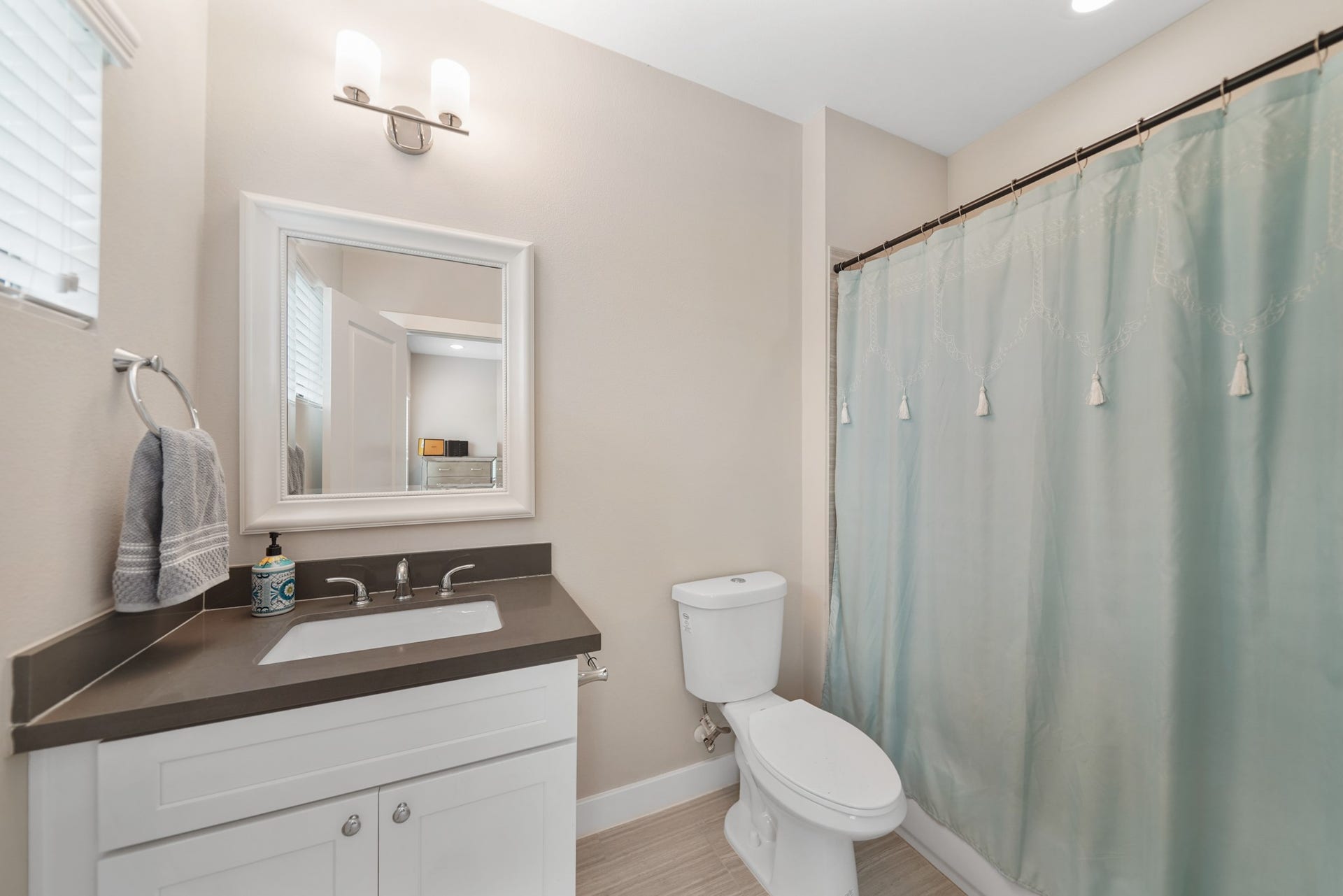 1824 Bonner Street, Houston, TX 77007 This private bath has a painted Shaker-style cabinet with a quartz counter top & integrated back splash highlighted by a framed mirror with wall mounted lighting above, a ceramic tile
surrounded combination tub/shower, window with blinds & tile floors.
