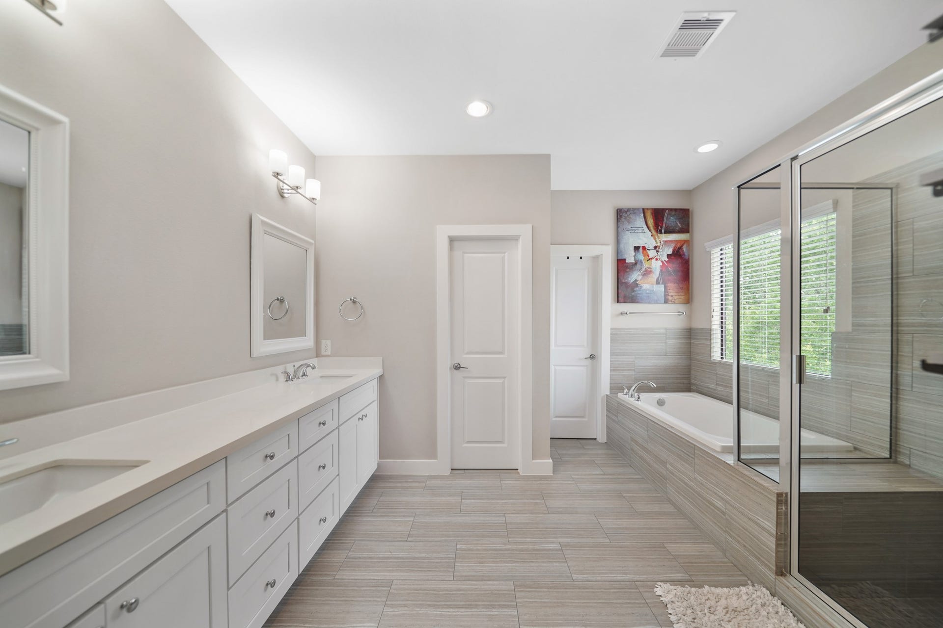 1824 Bonner Street, Houston, TX 77007 Luxury awaits you in this well appointed private bath with recessed lighting, painted Shaker-style cabinets supporting a quartz counter top with dual under-mount sinks and framed mirrors with wall mounted lighting above.