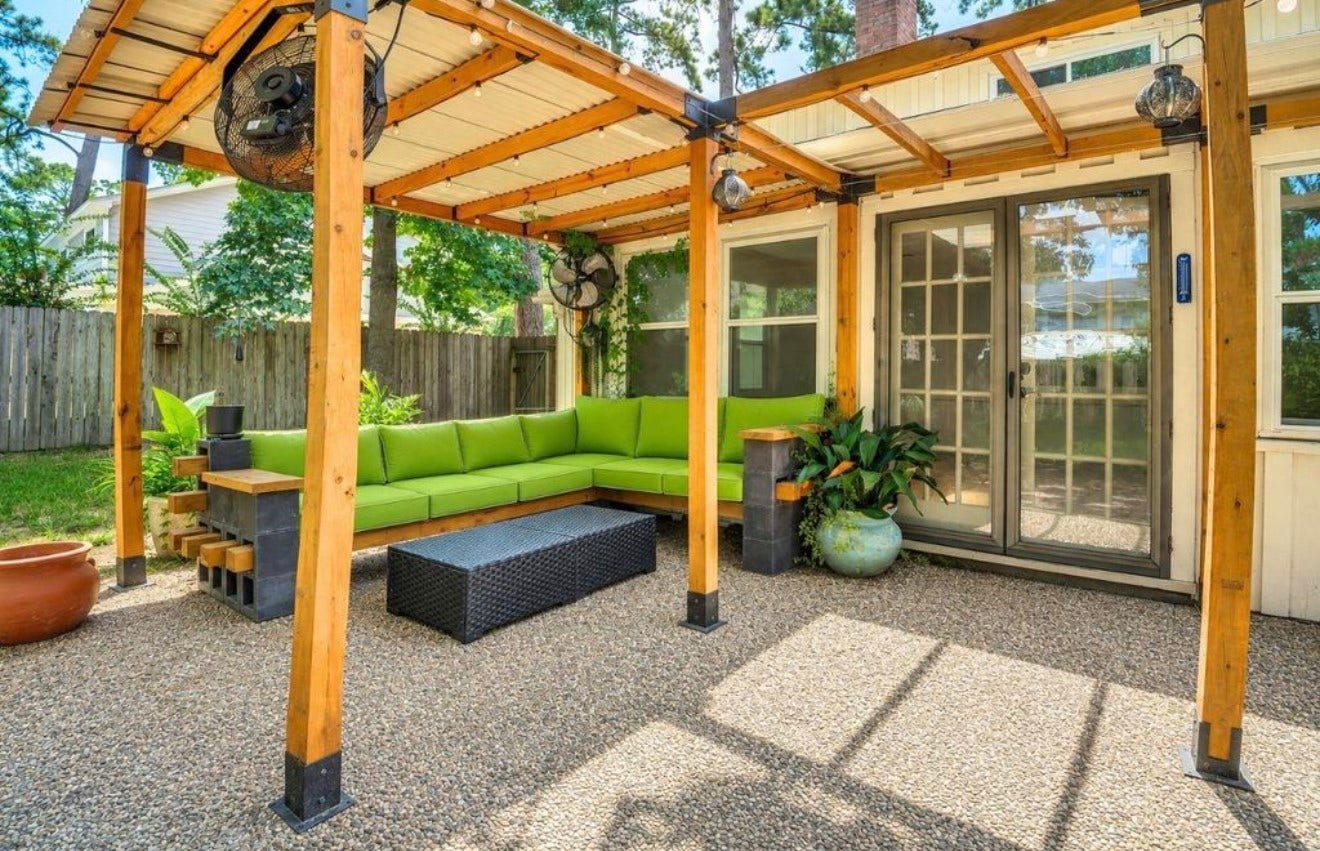 10818 Elmdale Drive, Houston, TX 77070 Inviting covered outdoor living area featuring a custom wood pergola, built-in seating, string lights, and fans for added comfort. The perfect space to relax, unwind, or entertain while enjoying the privacy of the backyard.