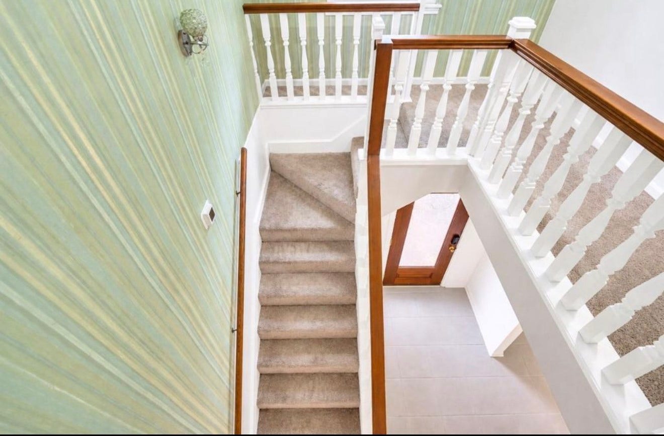 10818 Elmdale Drive, Houston, TX 77070 This perspective highlights the upper-level staircase with classic wood handrails and crisp white balusters, creating an open transition between the upper and main levels.