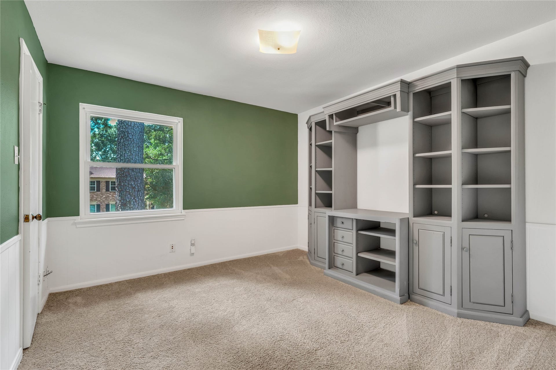 10818 Elmdale Drive, Houston, TX 77070 Upstairs bedroom featuring generous proportions, natural light, and impressive built-in cabinetry and shelving for added character and functionality.