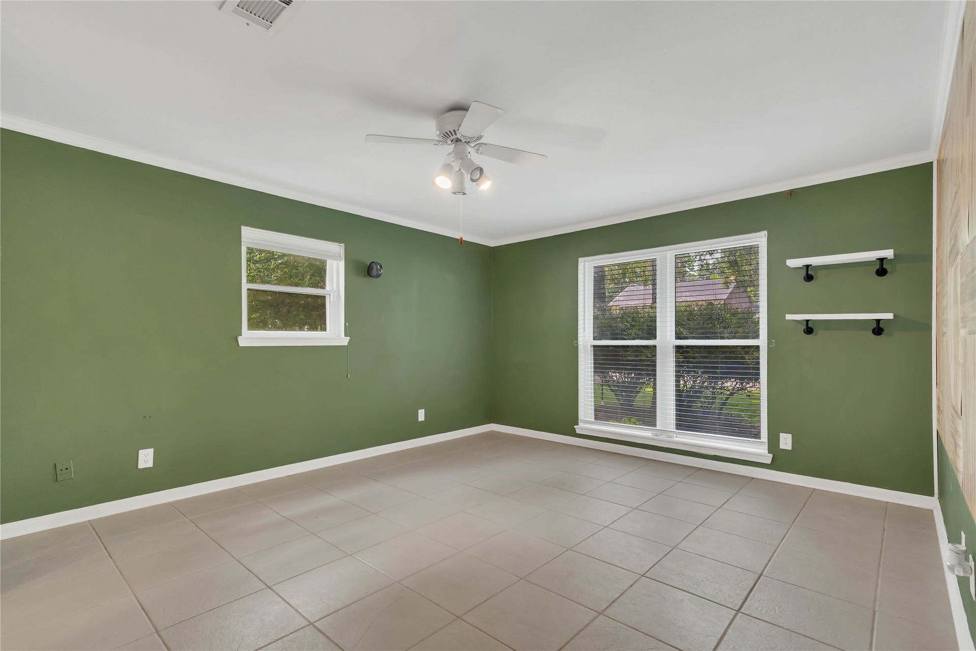 10818 Elmdale Drive, Houston, TX 77070 Expansive primary bedroom offering impressive proportions, abundant natural light from a wide set of windows, and a distinctive accent wall adding warmth and architectural character.