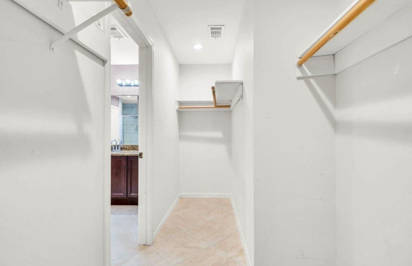 10818 Elmdale Drive, Houston, TX 77070 This perspective highlights the primary walk-in closets impressive depth, built-in storage, and direct connection to the primary bath.