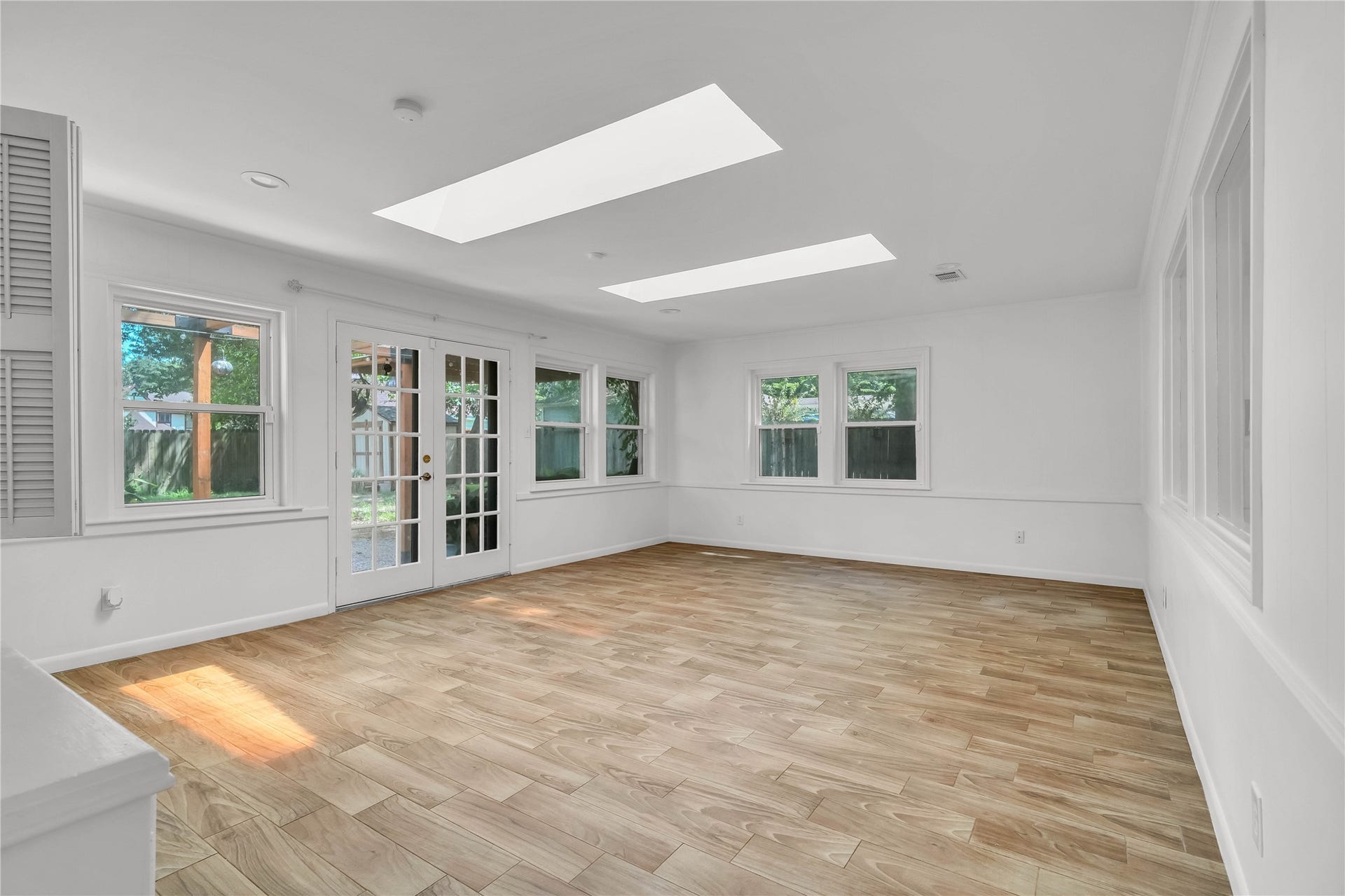 10818 Elmdale Drive, Houston, TX 77070 Expansive Light-filled sunroom featuring abundant windows, skylights, and an open, versatile layout.