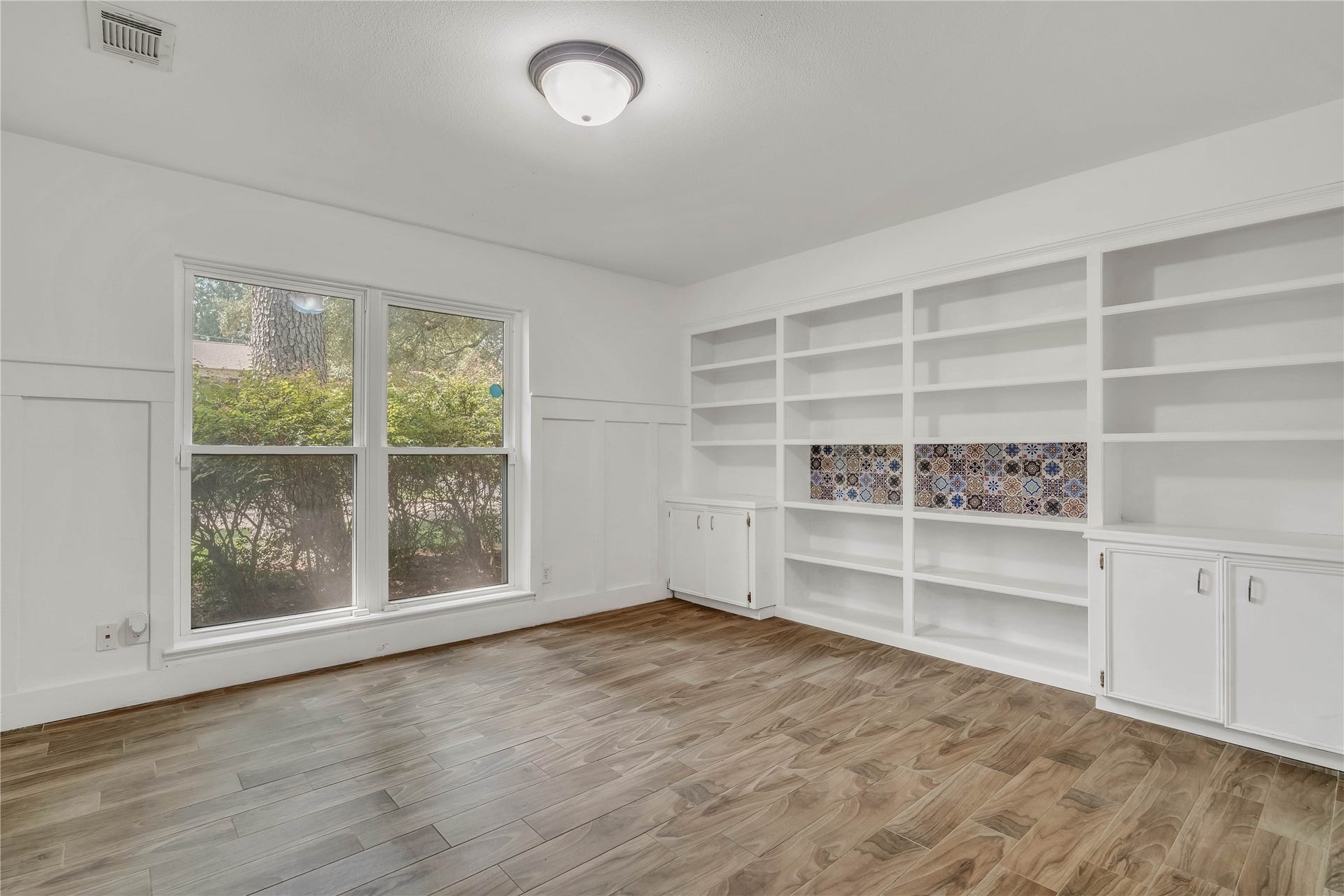 10818 Elmdale Drive, Houston, TX 77070 Expansive downstairs home office featuring an impressive wall of built-in shelving and cabinetry, abundant natural light, and exceptional space for a sophisticated home office.