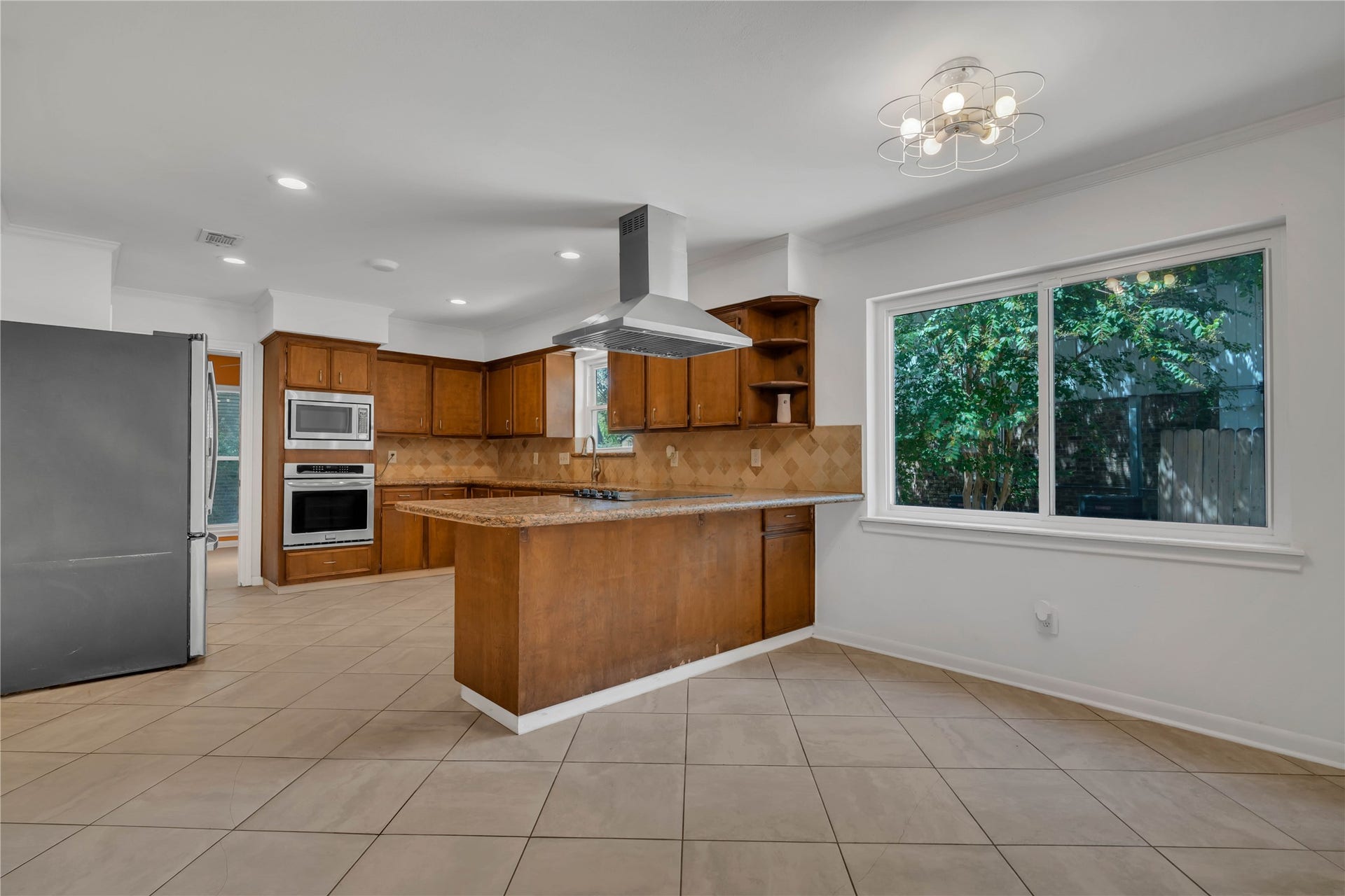 10818 Elmdale Drive, Houston, TX 77070 Spacious breakfast room filled with natural light, positioned just off the kitchen with views of the granite peninsula, abundant cabinetry, and cooktop.