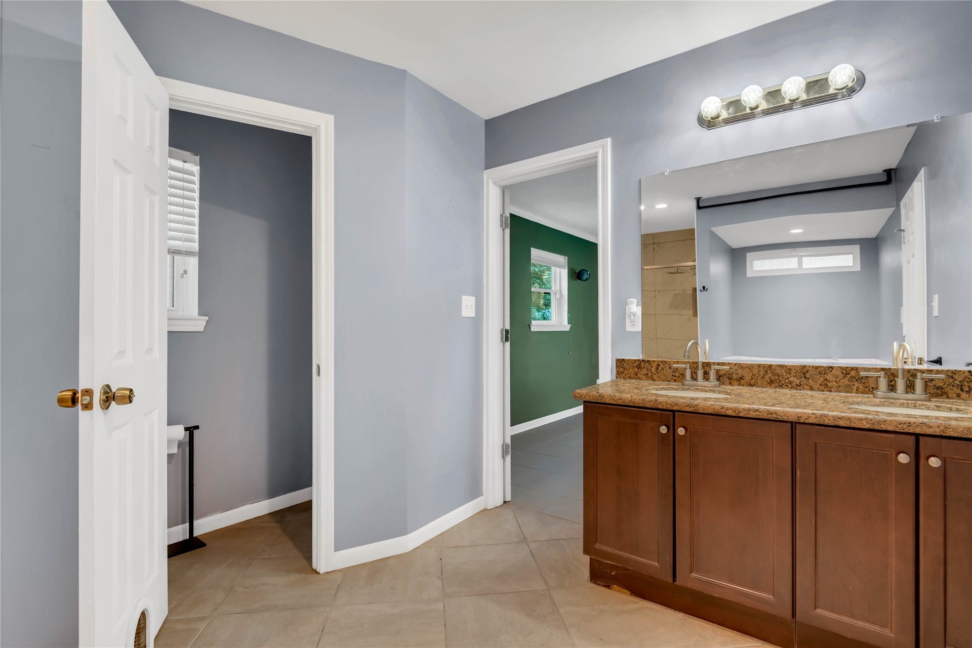 10818 Elmdale Drive, Houston, TX 77070 The primary bath also features a double vanity with granite countertops, ample counter space, and convenient cabinetry for storage.
