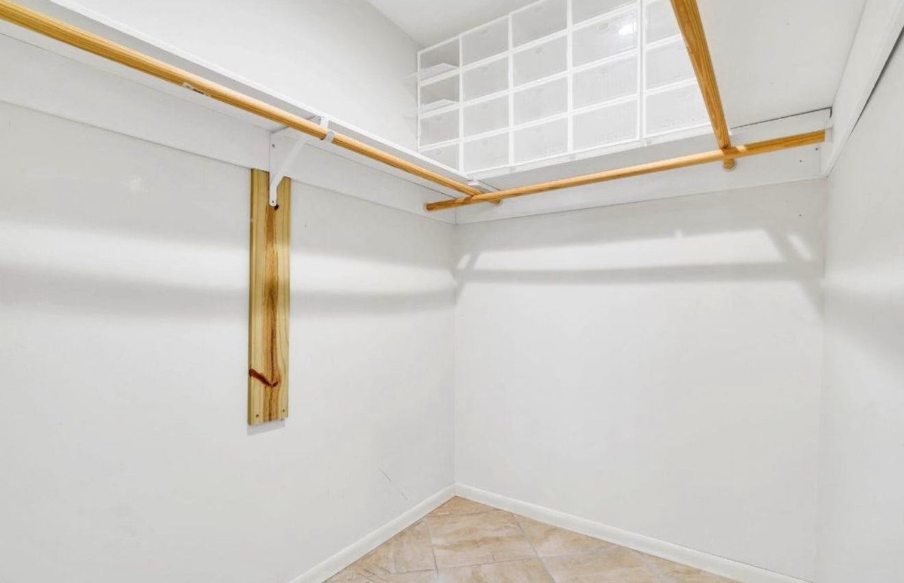 10818 Elmdale Drive, Houston, TX 77070 Spacious primary walk-in closet featuring extensive built-in shelving and multiple hanging areas for organized storage.