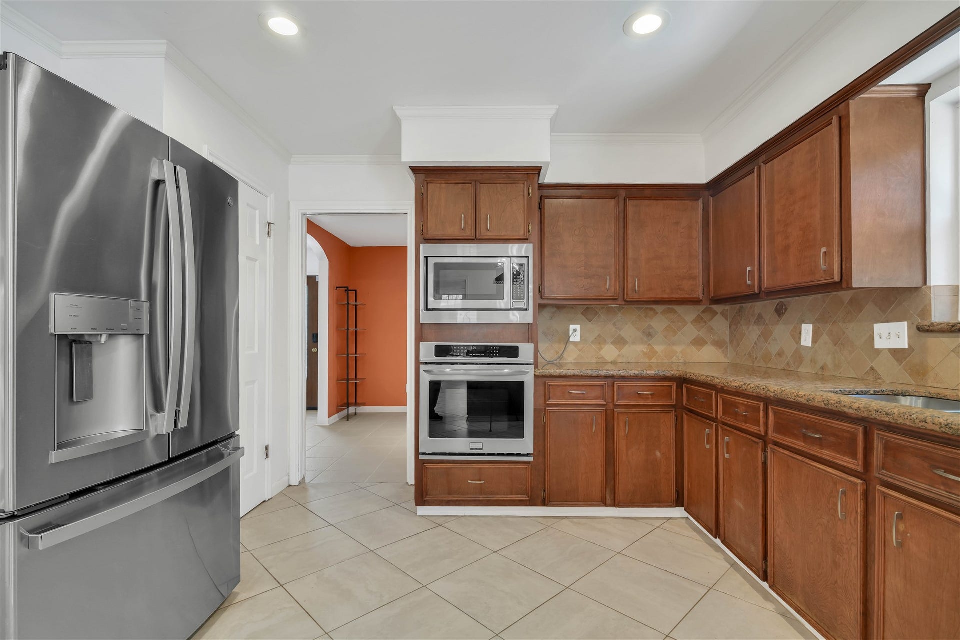 10818 Elmdale Drive, Houston, TX 77070 Spacious kitchen featuring granite countertops, abundant cabinetry, stainless steel appliances, and built-in double ovens, with a view into the adjoining formal dining room.