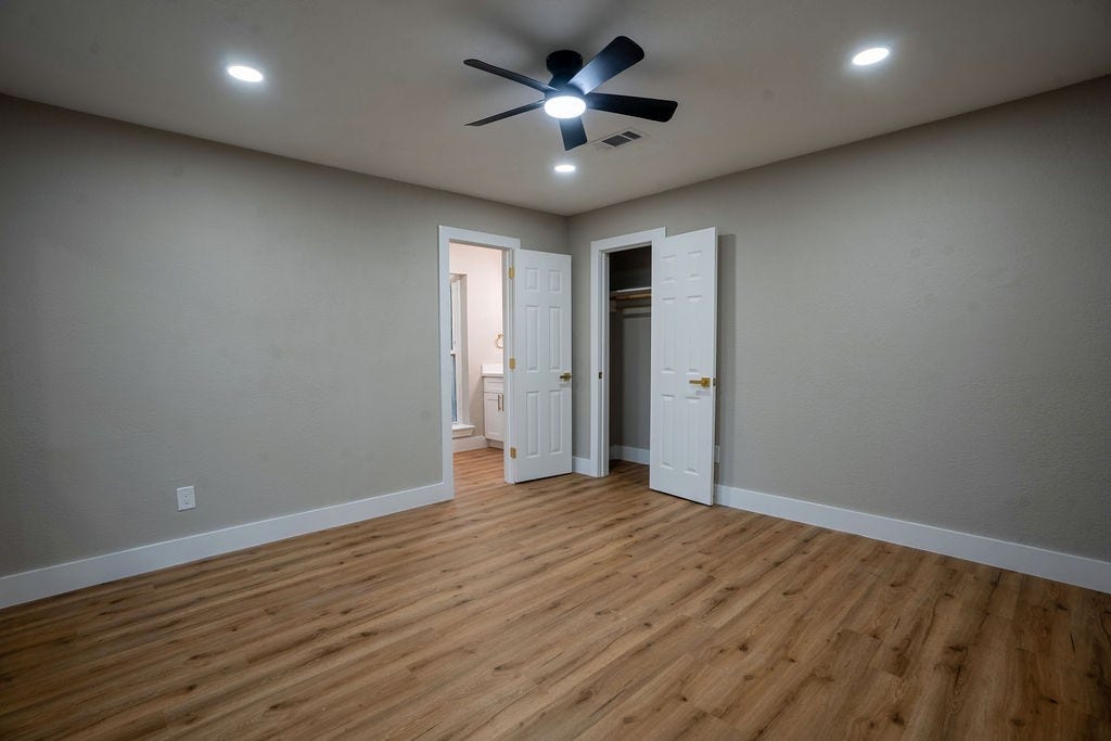 9856 Oriole, Conroe, TX 77385 Spacious bedroom featuring stylish wood style flooring, modern recessed lighting, and a ceiling fan, with convenient access to an ensuite bathroom and closet.