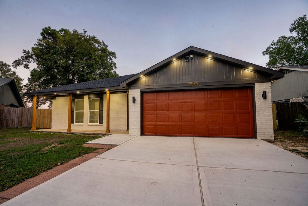 9856 Oriole, Conroe, TX 77385 Charming single-story home with a sleek modern facade, featuring a spacious two-car garage and elegant exterior lighting.