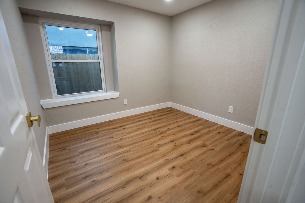 9856 Oriole, Conroe, TX 77385 Bright room featuring warm wood style flooring, neutral walls, and a large window for natural light.