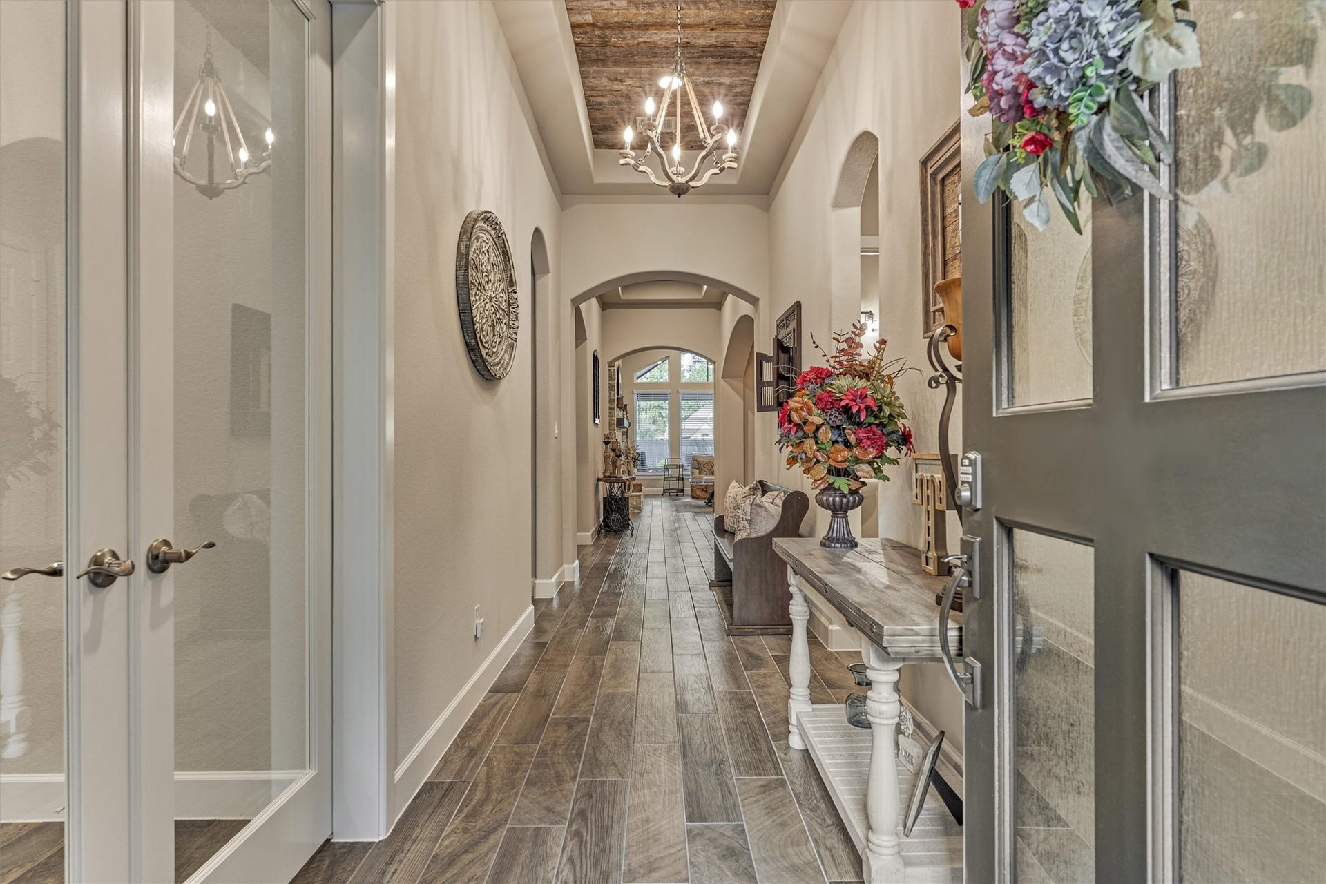 305 Pewter Sky Drive, Montgomery, TX 77316 A welcoming entry sets the tone with wood-look tile flooring, graceful arched details, upgraded chandelier and a dramatic tray ceiling accented with reclaimed wood.