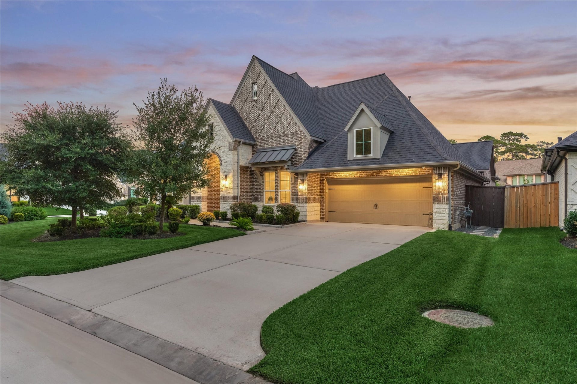 305 Pewter Sky Drive, Montgomery, TX 77316 Beautiful curb appeal featuring timeless brick and stone architecture, lush landscaping, mature trees and an inviting covered entry, wide & long driveway all on a desirable corner lot.