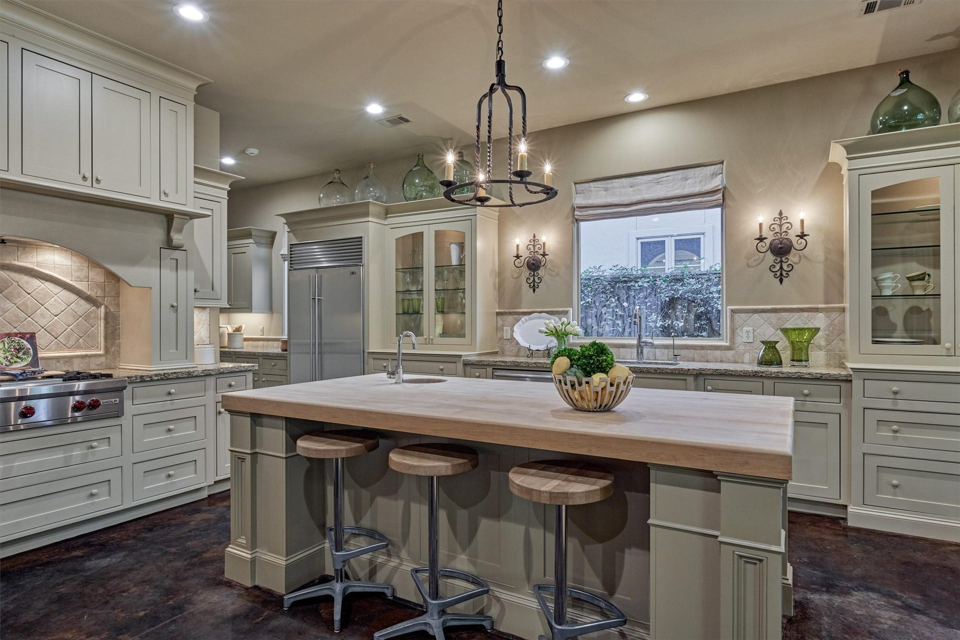 7 Dorset Square, The Woodlands, TX 77381 Chefs kitchen - features include butcher-block island, Sub-Zero refrigerator, Wolf gas cooktop with griddle, vegetable sink, glass display cabinets & pull-out spice racks.