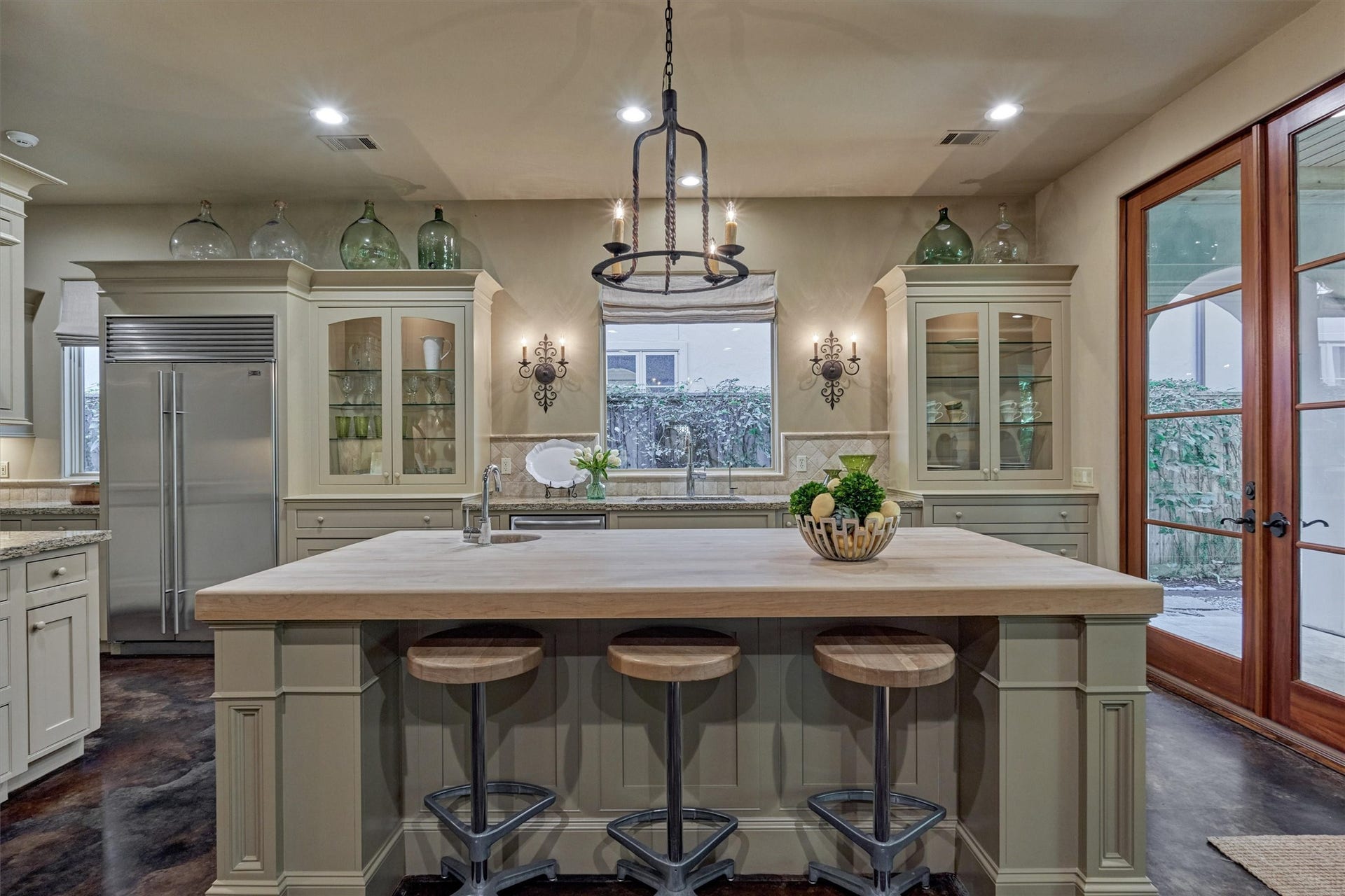7 Dorset Square, The Woodlands, TX 77381 Kitchen provides an inviting and functional space with large butcher block countertop island that has wine bottle storage (not pictured), seating and a vegetable sink.
