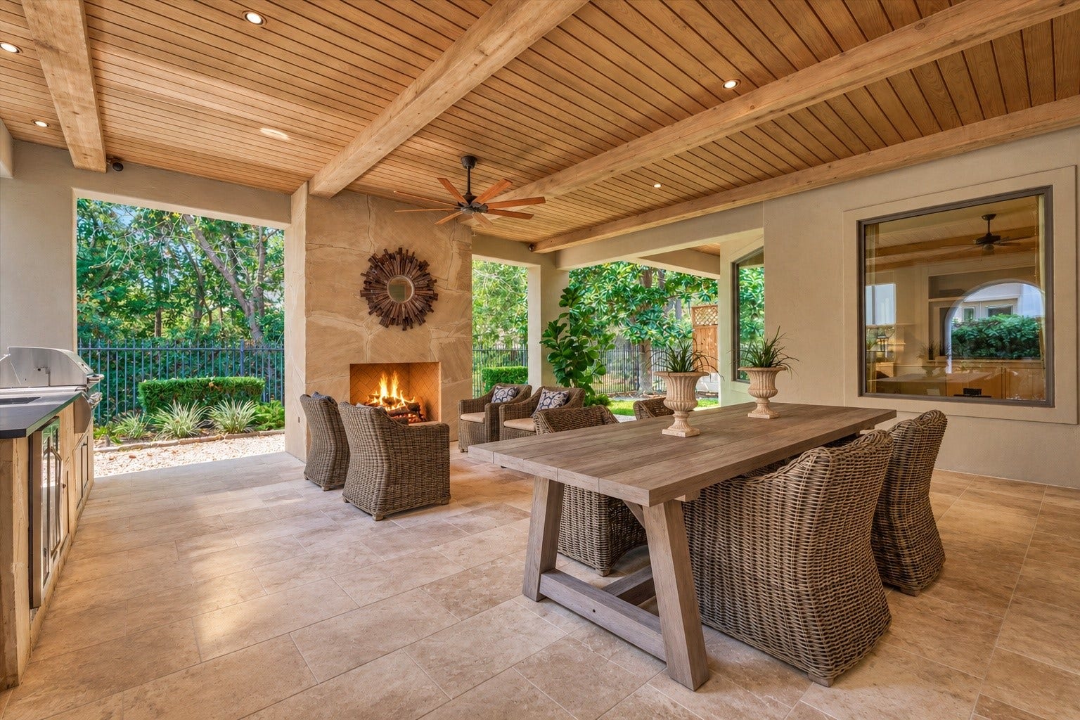 7 Dorset Square, The Woodlands, TX 77381 Extensive loggia / covered patio with dining, exterior living, outdoor kitchen, mosquito system and cozy outdoor fireplace. Photo is virtually staged/enhanced.