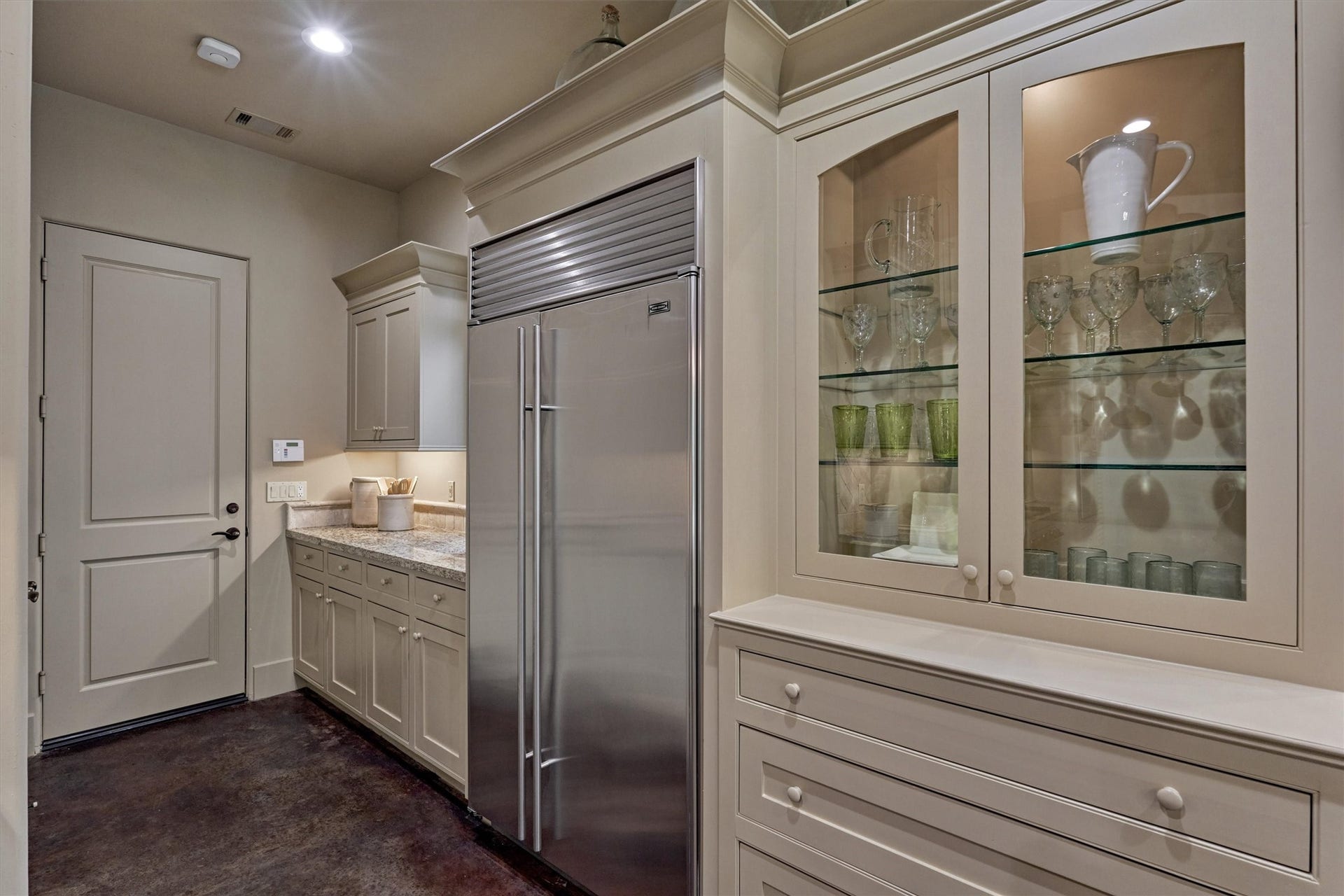 7 Dorset Square, The Woodlands, TX 77381 Built-in stainless steel Sub-Zero, prep counter with under counter lighting and custom cabinetry with glass display.