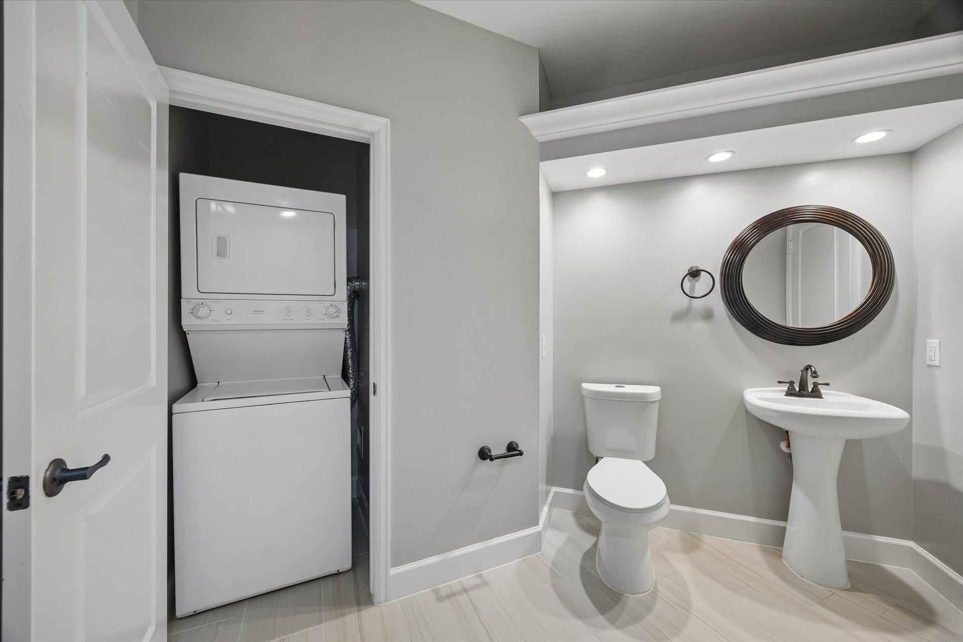 2203 Dorrington Street Street, #205, Houston, TX 77030 This modern bathroom featuring a walk- in shower, pedestal sink, and new toilet. It includes a convenient in-unit stacked washer and dryer and recessed lighting.