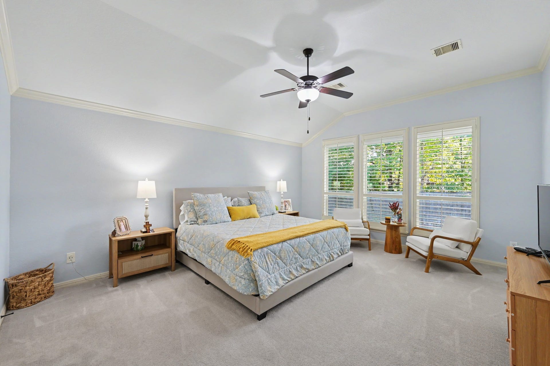 271 Rio Ranch Circle, Montgomery, TX 77316 Spacious bedroom with soft blue walls, large windows allowing natural light, and a cozy seating area, creating a serene retreat.