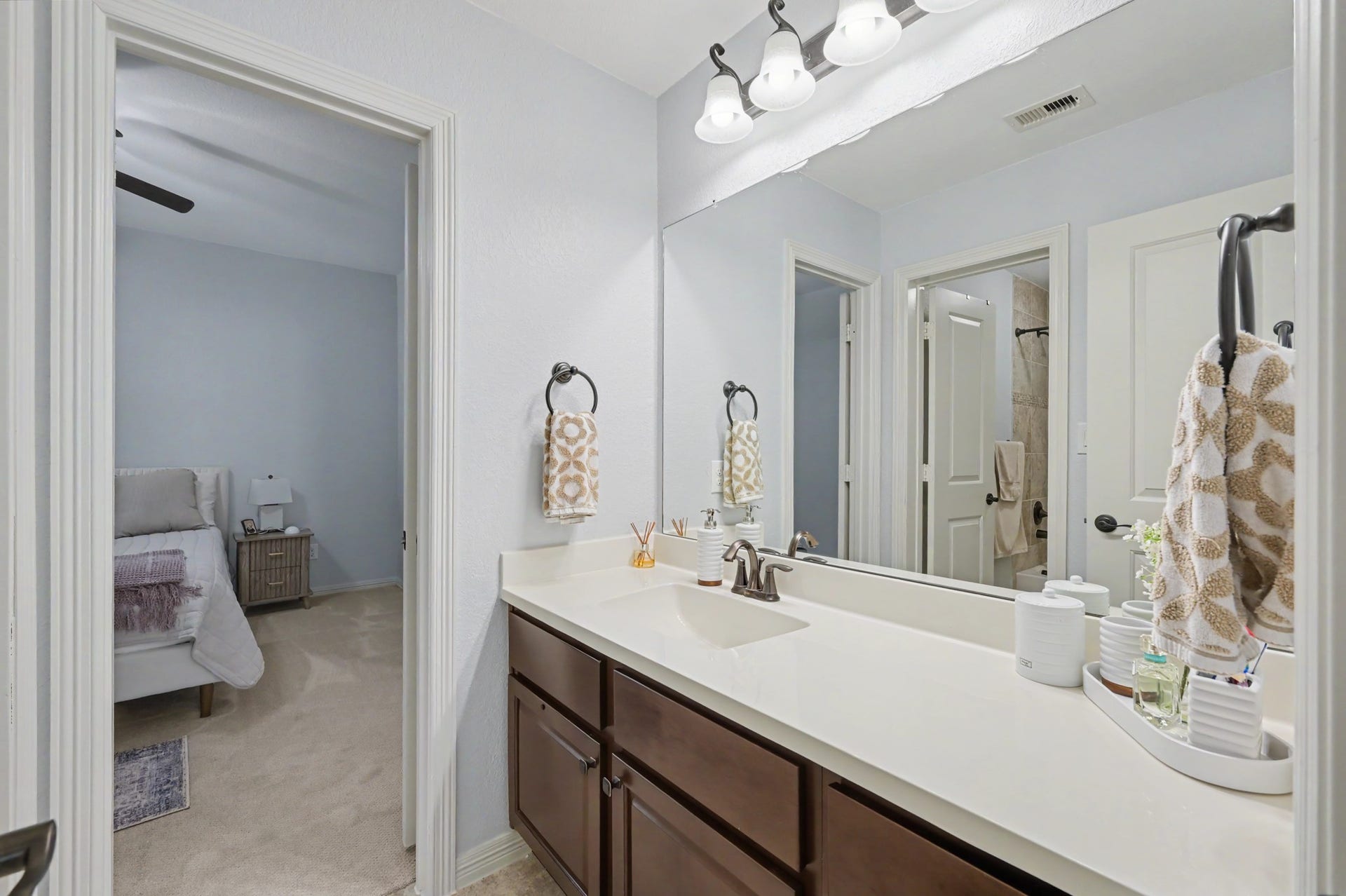 271 Rio Ranch Circle, Montgomery, TX 77316 Elegant bathroom featuring a spacious dual-sink vanity, modern lighting, and direct access to a cozy bedroom.