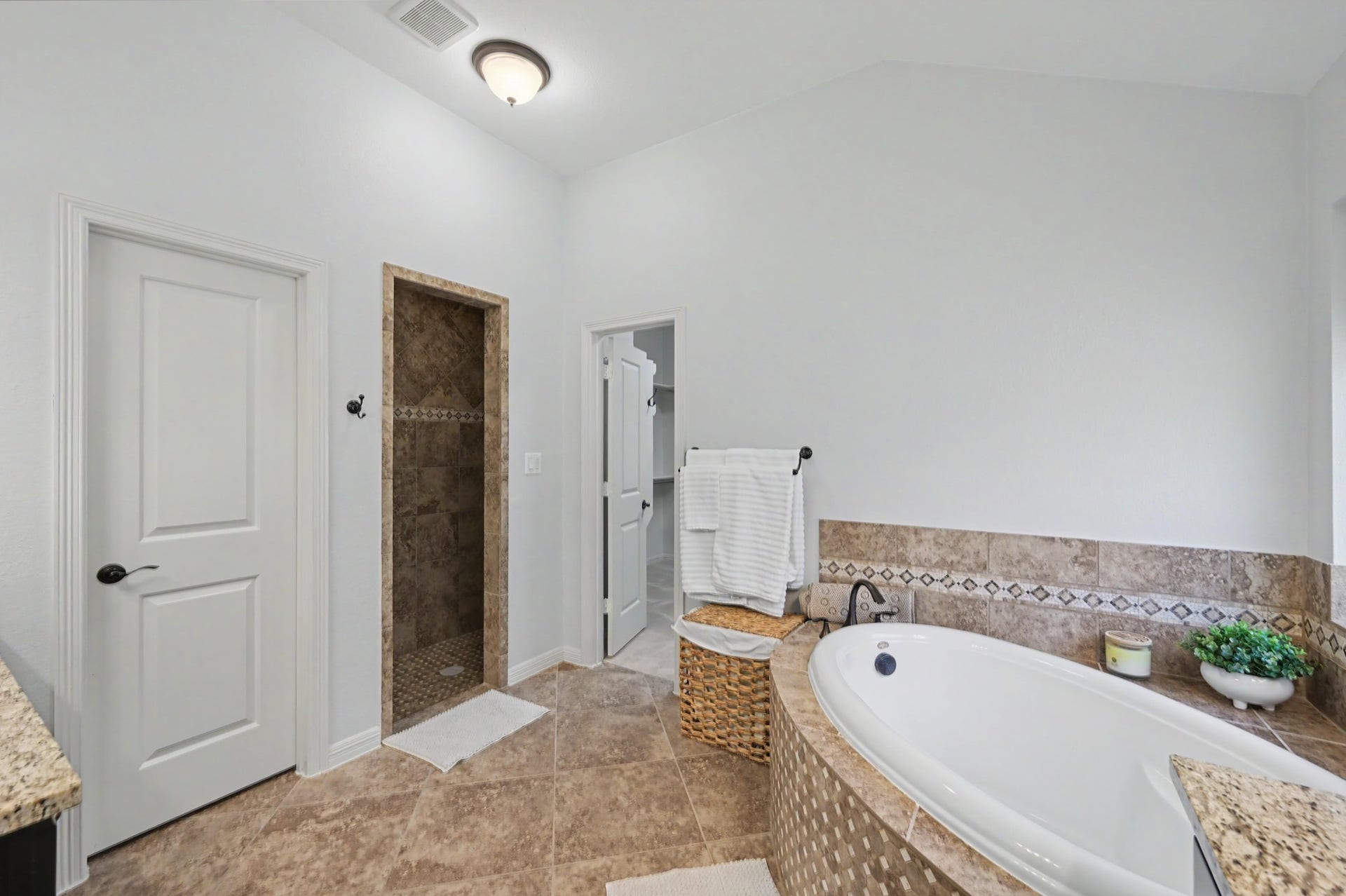 271 Rio Ranch Circle, Montgomery, TX 77316 Luxurious bathroom featuring a spacious corner bathtub with elegant tile accents, a walk-in shower, and ample natural light for a serene atmosphere.
