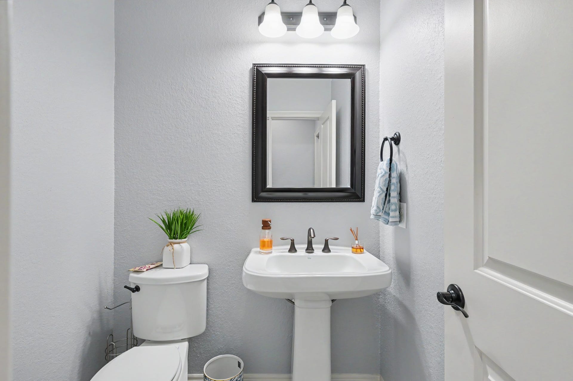 271 Rio Ranch Circle, Montgomery, TX 77316 Charming powder room featuring a pedestal sink, sleek fixtures, and a stylish framed mirror, perfectly accented by bright lighting and a neutral color palette.