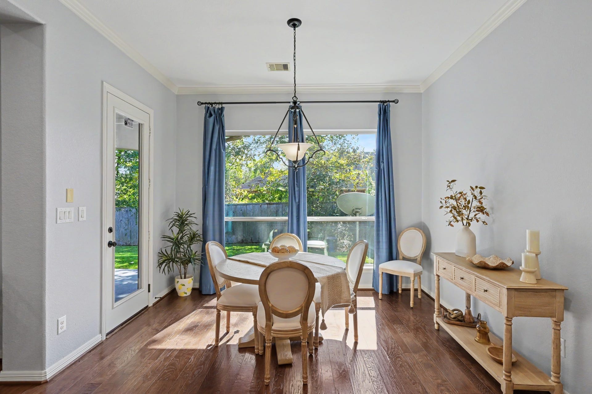 271 Rio Ranch Circle, Montgomery, TX 77316 Bright dining area featuring elegant wood flooring and abundant natural light, with a charming view of the backyard through large windows and a glass door.