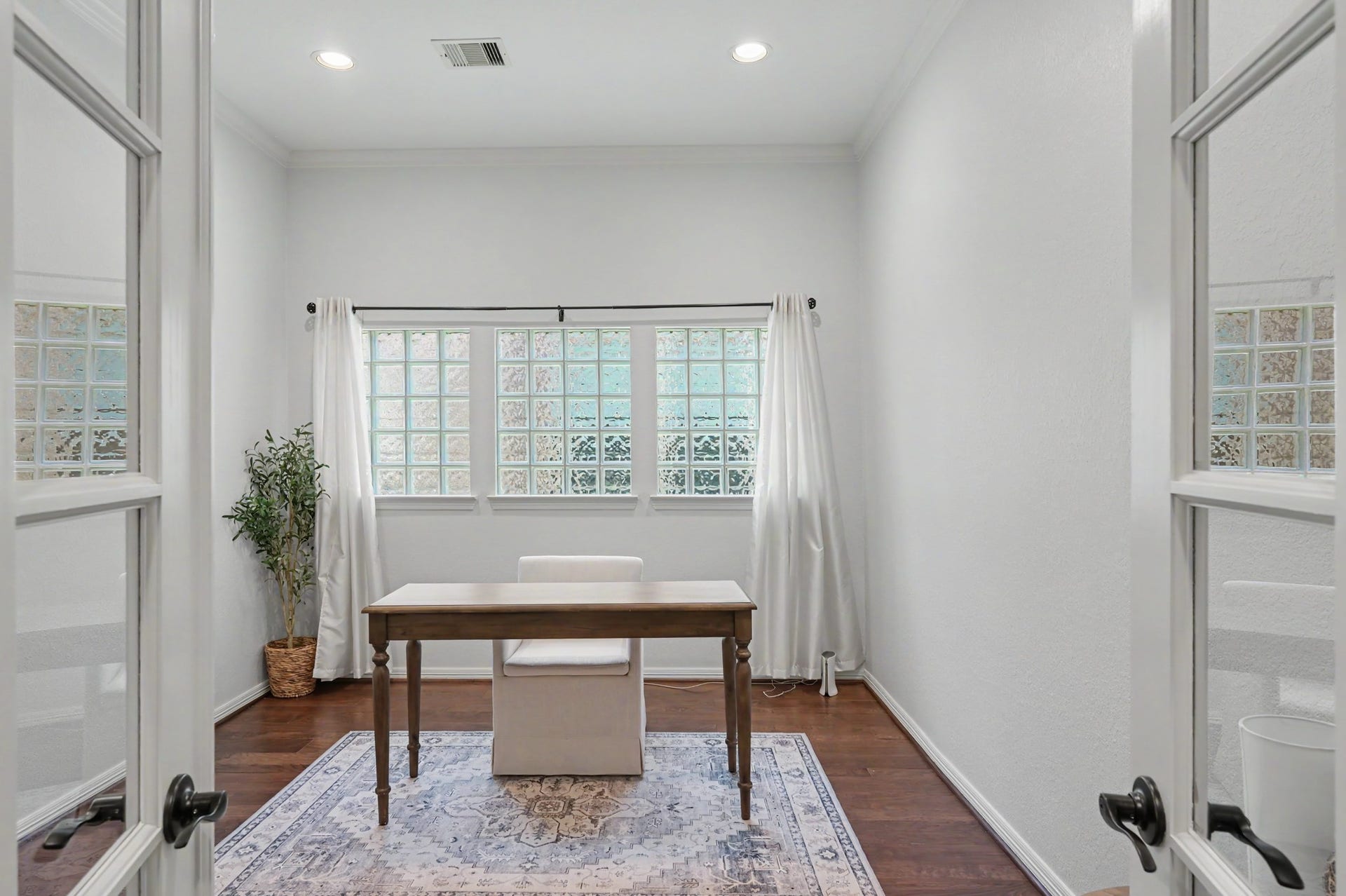 271 Rio Ranch Circle, Montgomery, TX 77316 Bright and inviting home office with elegant French doors, featuring hardwood floors and a large window offering ample natural light.