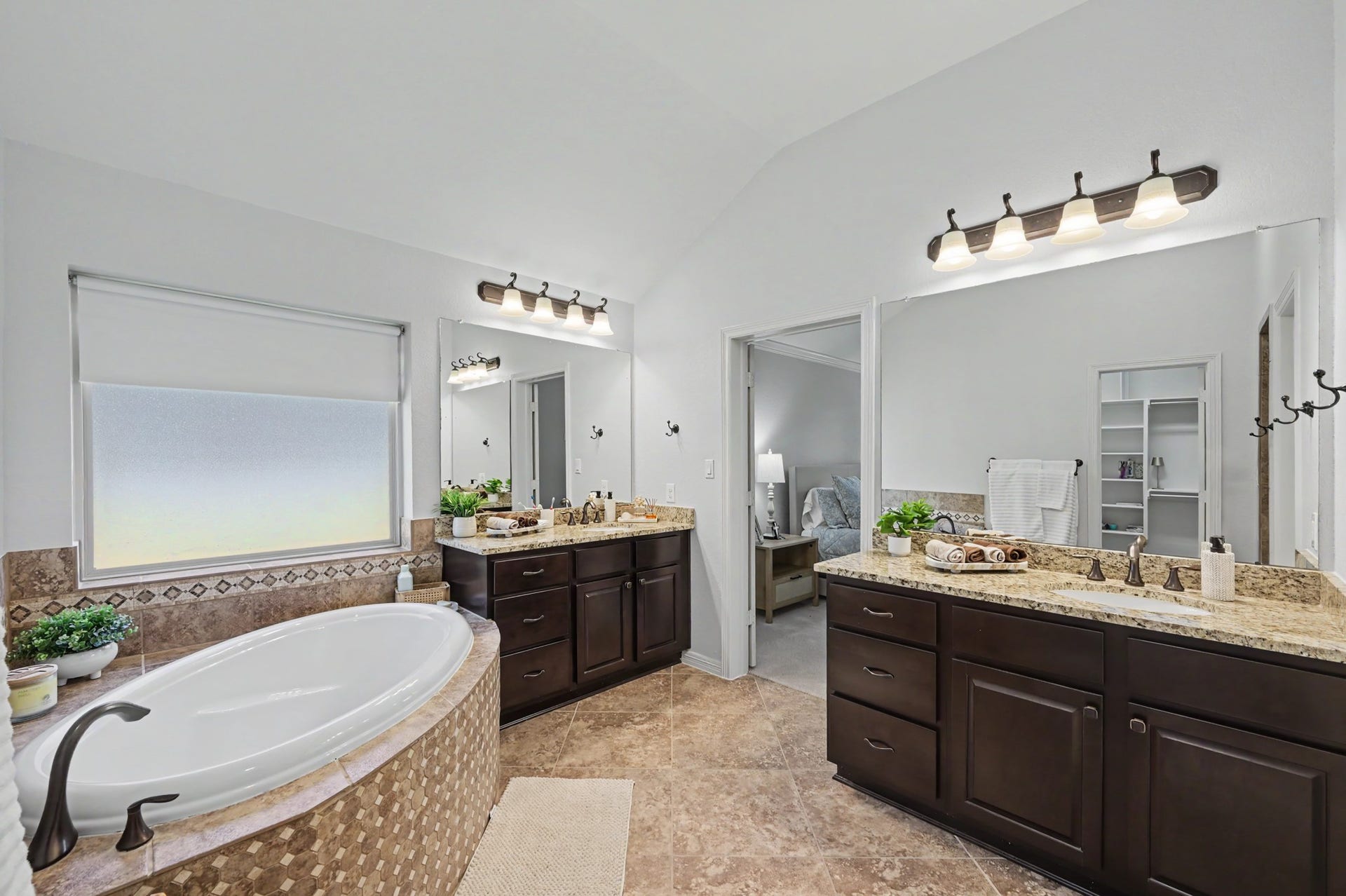 271 Rio Ranch Circle, Montgomery, TX 77316 Spacious and elegant bathroom featuring a luxurious soaking tub, dual vanities with granite countertops, and warm wood cabinetry, offering both style and functionality.