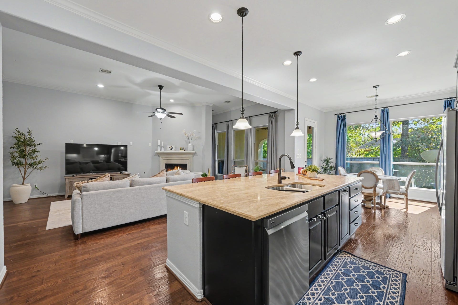 271 Rio Ranch Circle, Montgomery, TX 77316 Spacious open-concept living area featuring a modern kitchen with a large island, elegant pendant lighting, and ample natural light from large windows, perfect for entertaining and family gatherings.