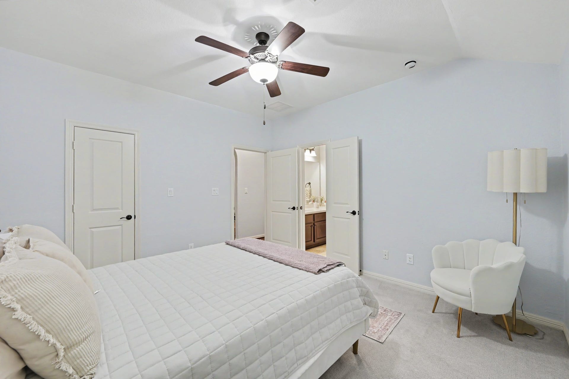 271 Rio Ranch Circle, Montgomery, TX 77316 Bright and inviting bedroom with a ceiling fan, plush carpeting, and an ensuite bathroom for added convenience.