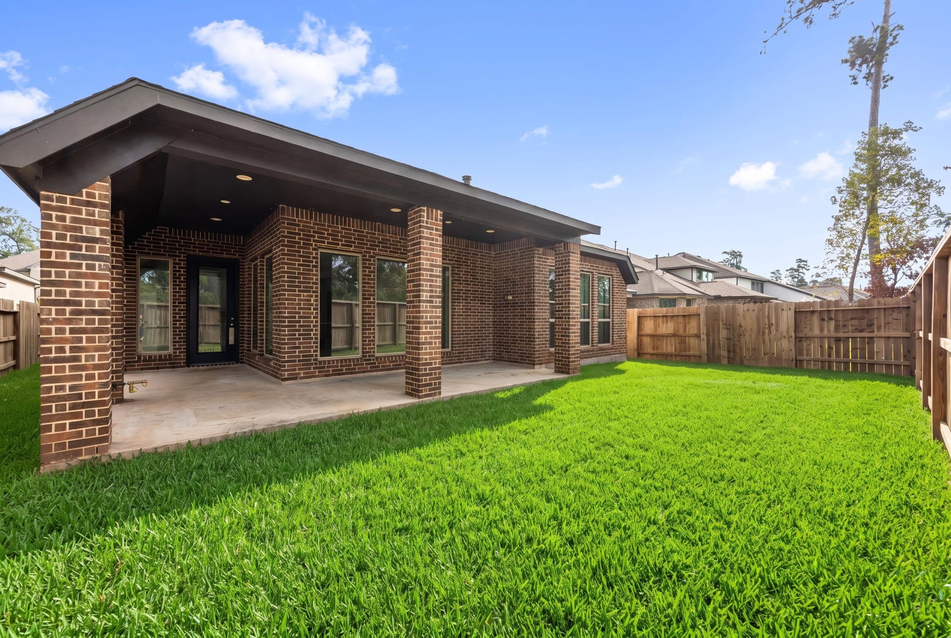 726 Fall Rock Branch Drive, Conroe, TX 77304 Enjoy the outdoors in this private, fully fenced backyard with lush green lawn and a spacious covered patio.