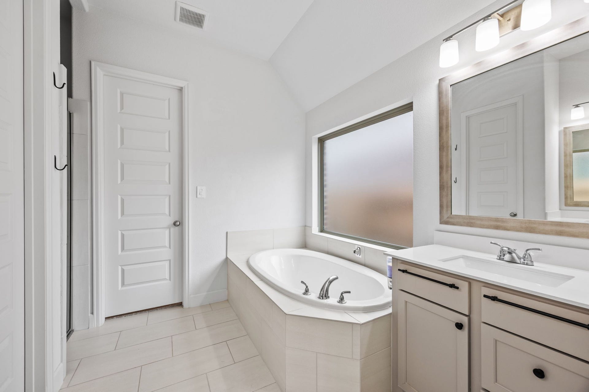 726 Fall Rock Branch Drive, Conroe, TX 77304 Relaxing bathroom retreat with a soaking tub, dual-sink vanity, and timeless finishes.