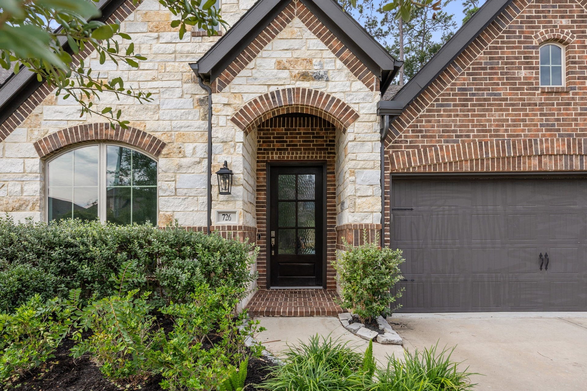 726 Fall Rock Branch Drive, Conroe, TX 77304 Timeless brick and stone exterior with charming architectural details and a welcoming covered entry.