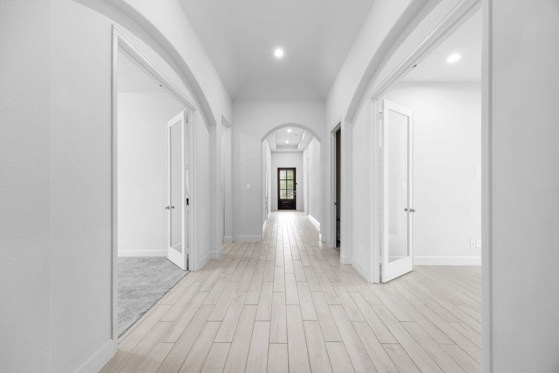 726 Fall Rock Branch Drive, Conroe, TX 77304 Elegant entryway featuring soaring ceilings, graceful archways, and beautiful wood-look flooring.