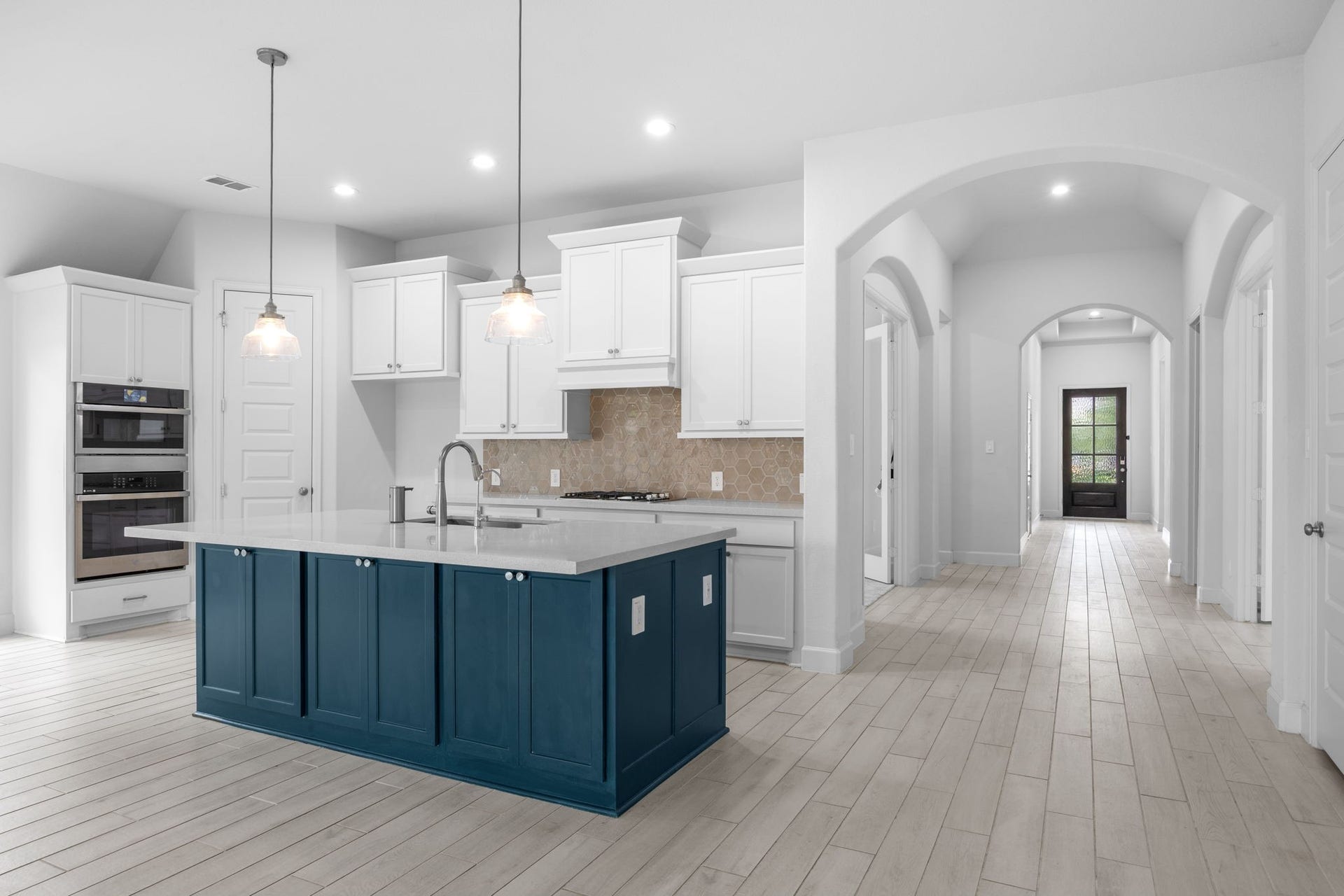 726 Fall Rock Branch Drive, Conroe, TX 77304 Stunning kitchen showcases a striking navy island, crisp white cabinetry, and an open, airy design.