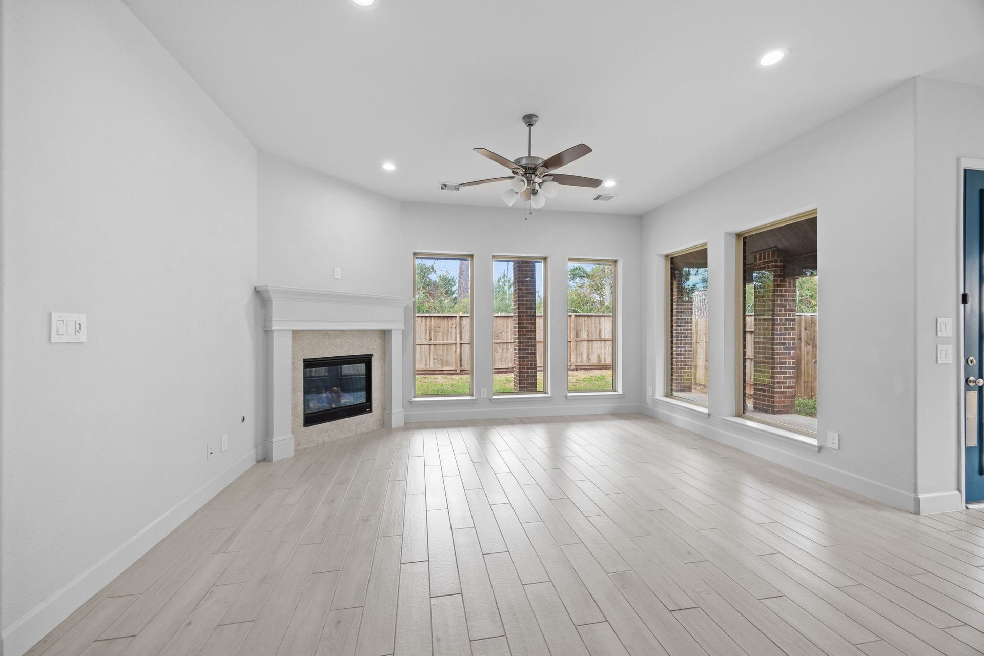 726 Fall Rock Branch Drive, Conroe, TX 77304 Bright and spacious living room featuring a cozy fireplace, high ceilings, and beautiful flooring.