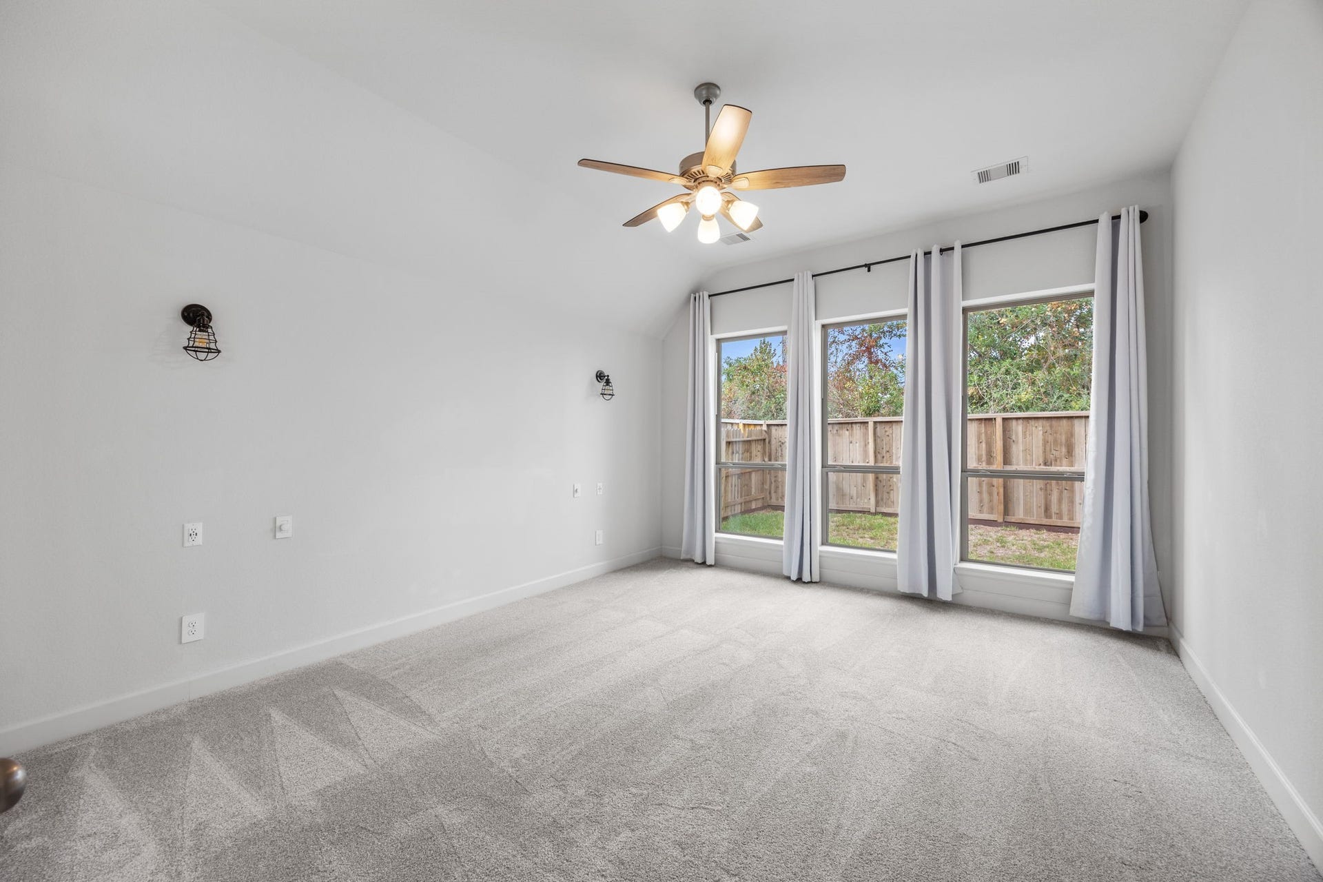 726 Fall Rock Branch Drive, Conroe, TX 77304 Spacious bedroom featuring a ceiling fan, beautiful flooring, and a wall of windows overlooking the outdoors.