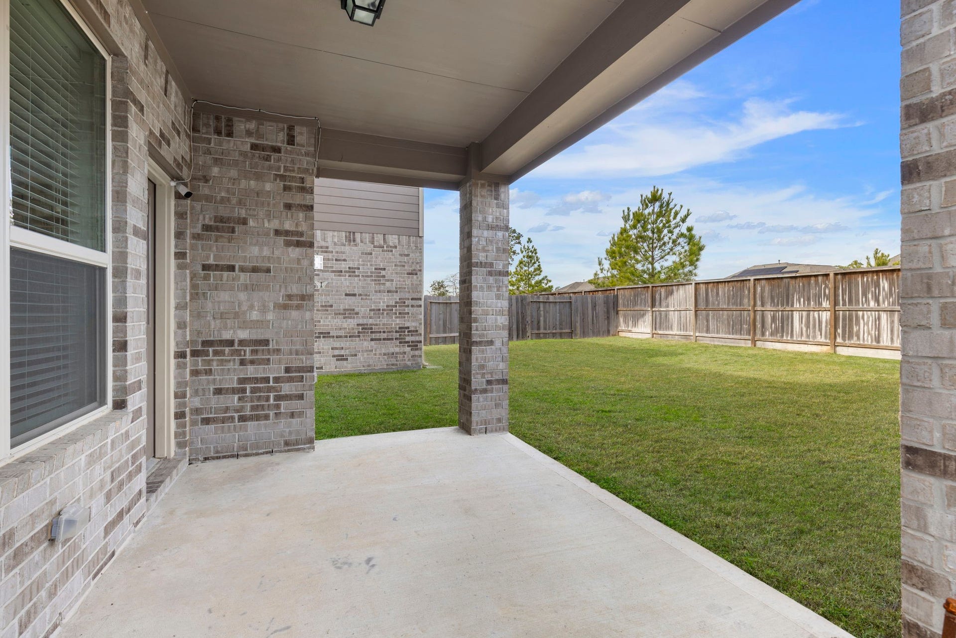 2819 Bradbury Hills Drive, Spring, TX 77373 Enjoy serene outdoor living with this inviting covered patio, perfect for relaxation and entertaining against a backdrop of lush green space.