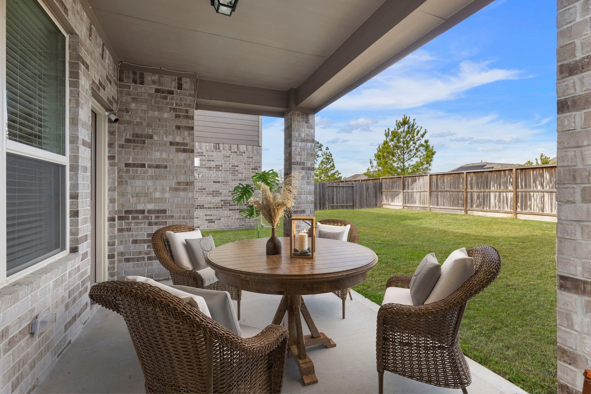 2819 Bradbury Hills Drive, Spring, TX 77373 Experience the perfect blend of comfort and style in this virtually staged patio, featuring cozy wicker seating around a charming round table, all set against the backdrop of a spacious, fenced-in yardideal for relaxing and entertaining.