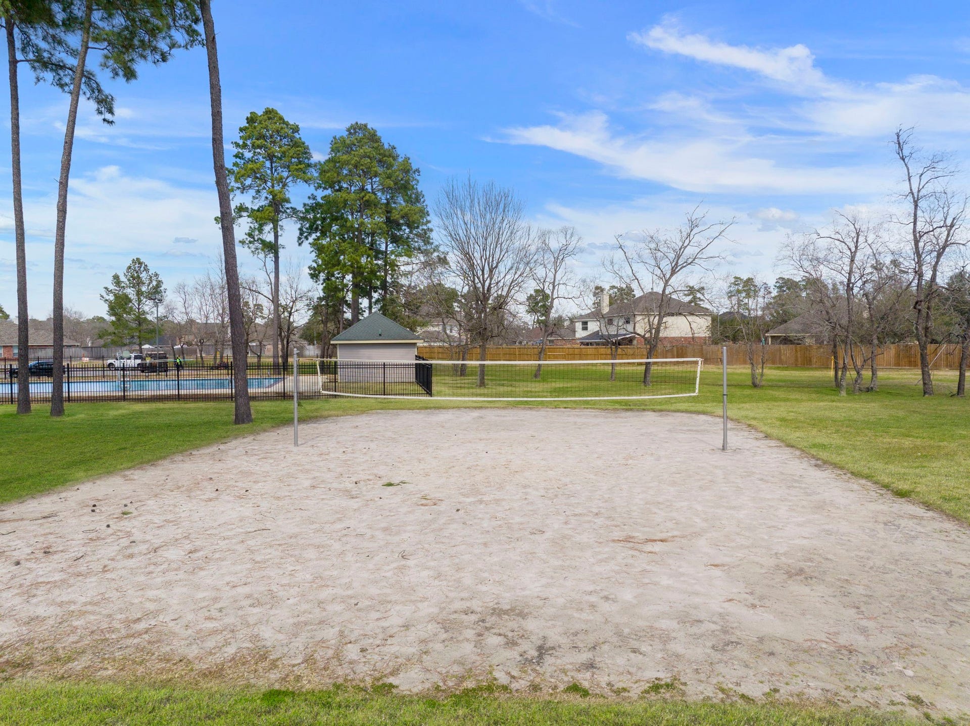 2819 Bradbury Hills Drive, Spring, TX 77373 Discover a vibrant community playground featuring a sandy volleyball court surrounded by lush greenery and towering trees, perfect for family fun and outdoor relaxation.