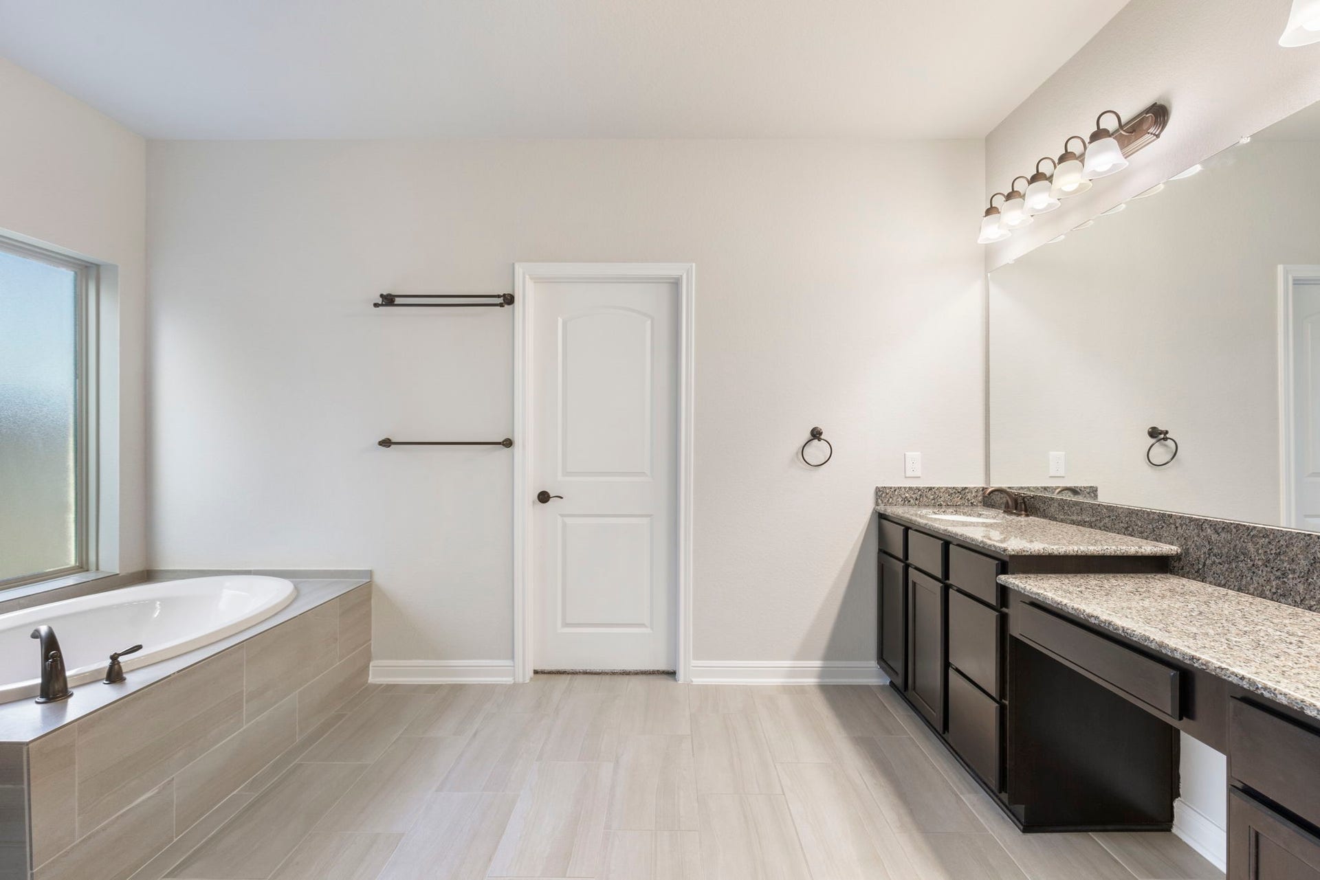 2819 Bradbury Hills Drive, Spring, TX 77373 Discover a serene oasis in this primary bathroom, featuring a spacious soaking tub, elegant dual vanities with granite countertops, and sleek modern fixtures, perfect for unwinding in style.