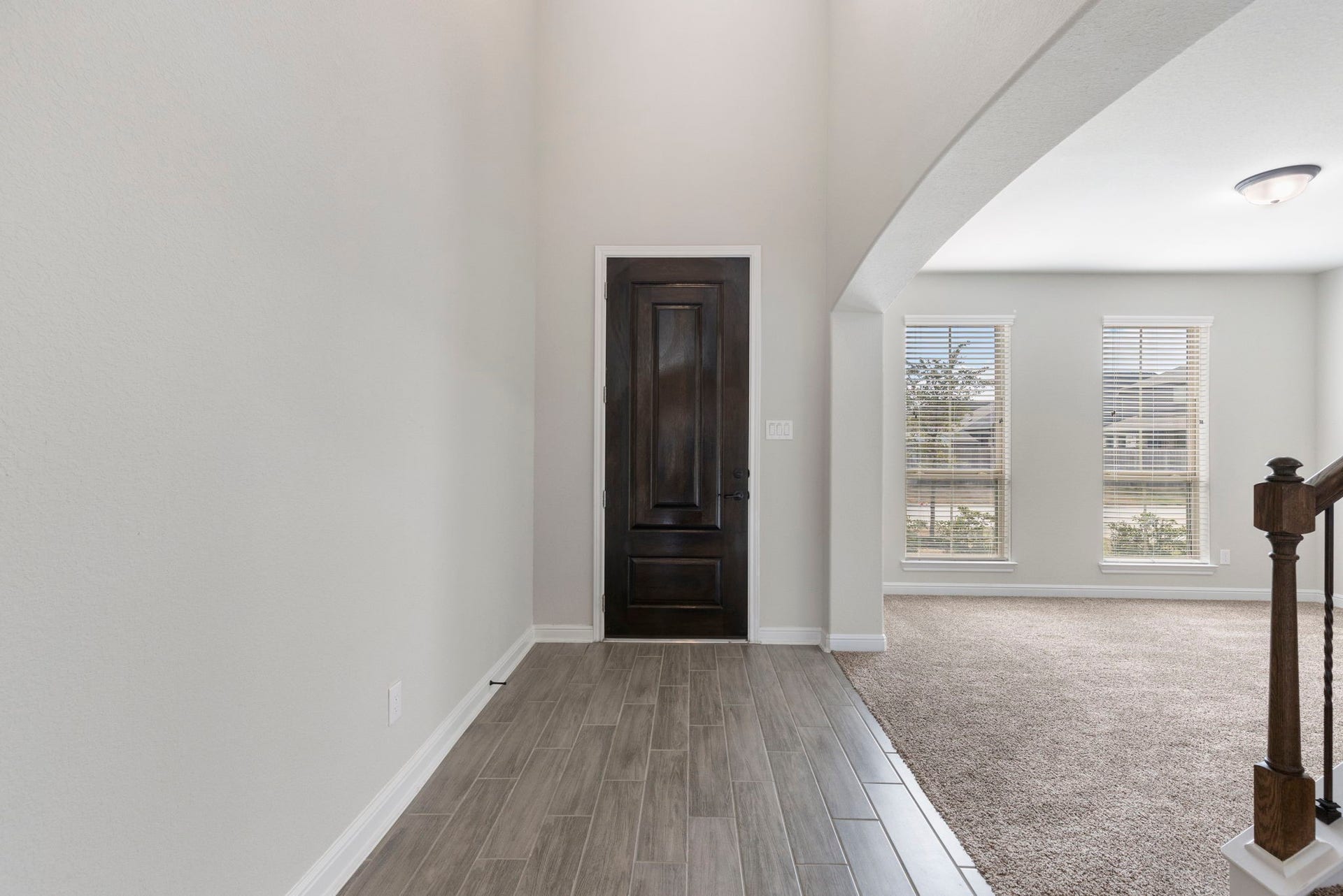 2819 Bradbury Hills Drive, Spring, TX 77373 Discover the welcoming elegance of this home's foyer, featuring sleek tile flooring, a rich wooden door, and an inviting archway leading to a bright, spacious living area.
