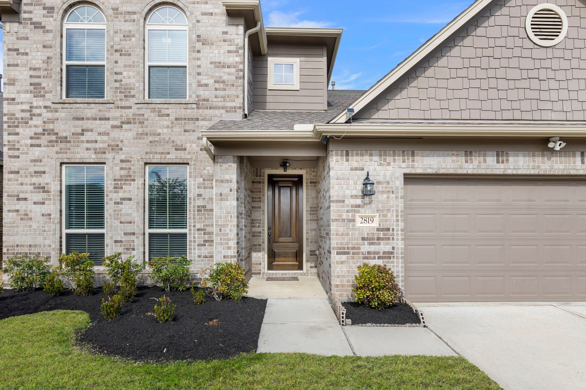 2819 Bradbury Hills Drive, Spring, TX 77373 This charming home features a welcoming porch, framed by elegant brickwork and lush landscaping, promising a warm and inviting entrance.