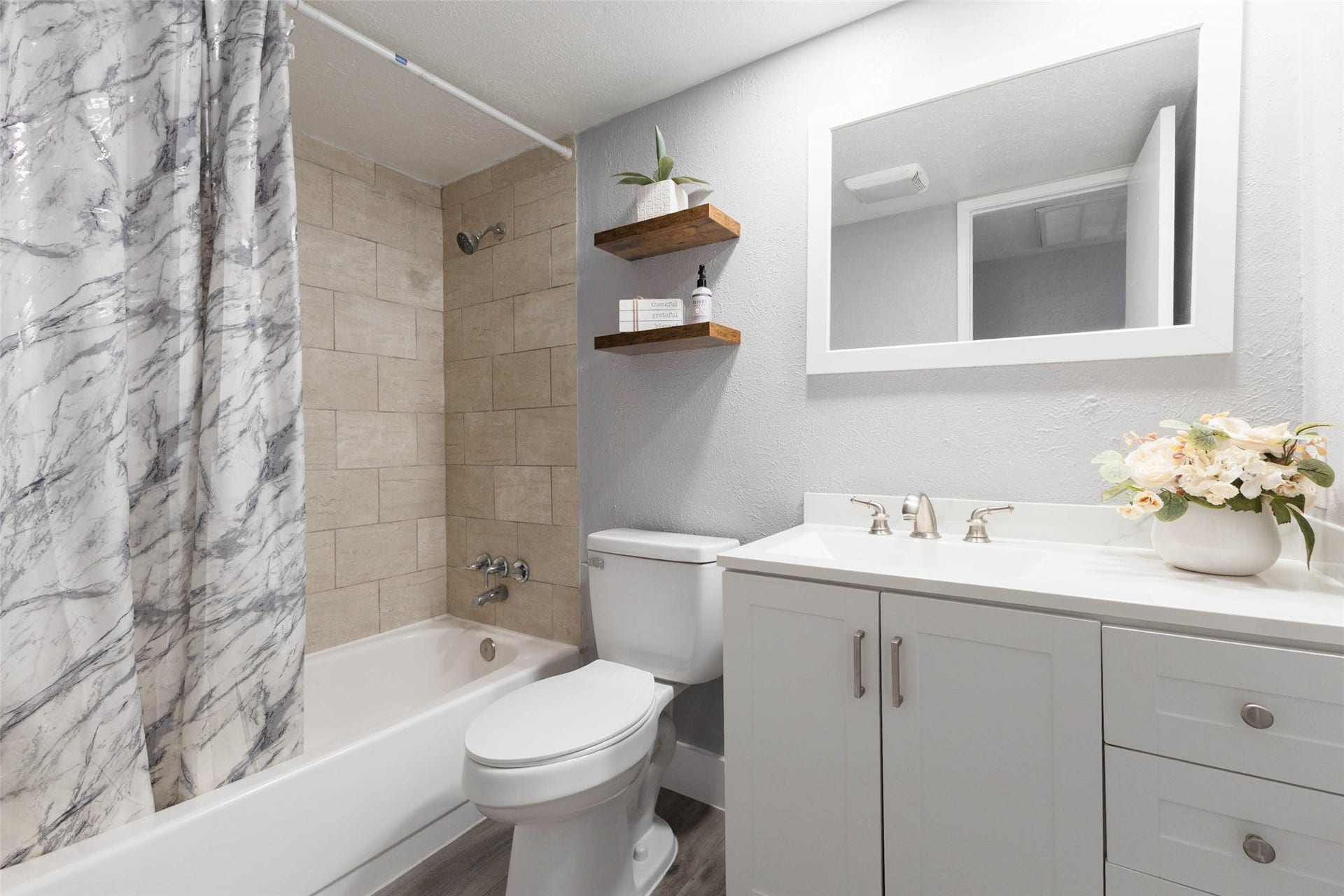 17302 S Yorkglen Drive, Houston, TX 77084 Updated bathroom with a tiled walk-in shower and modern floating shelving."