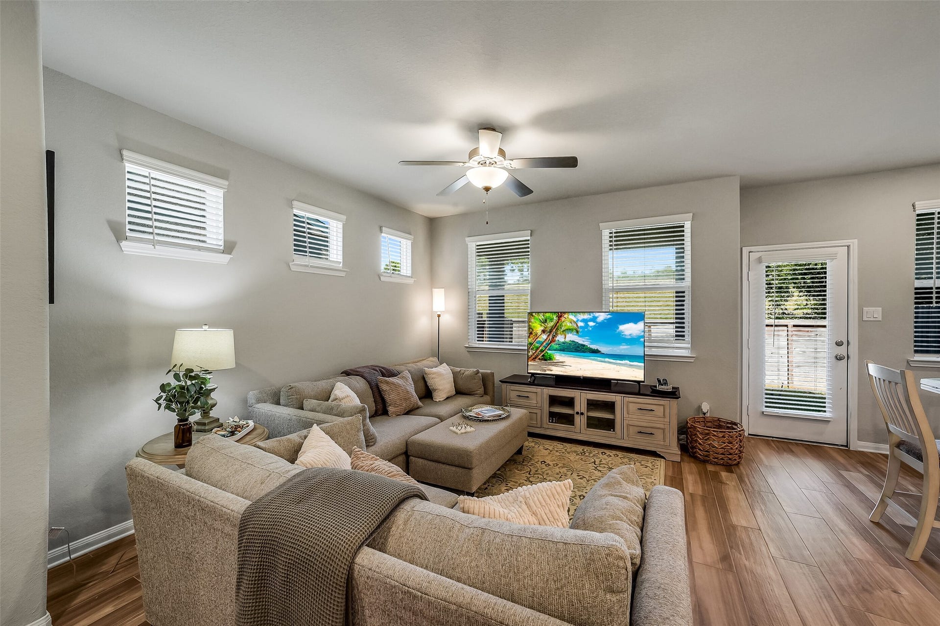 Settle in for a quiet evening or gather with friends in this comfortable living room, featuring windows on multiple walls and a ceiling fan.Settle in for a quiet evening or gather with friends in this comfortable living room, featuring windows on multiple walls and a ceiling fan.